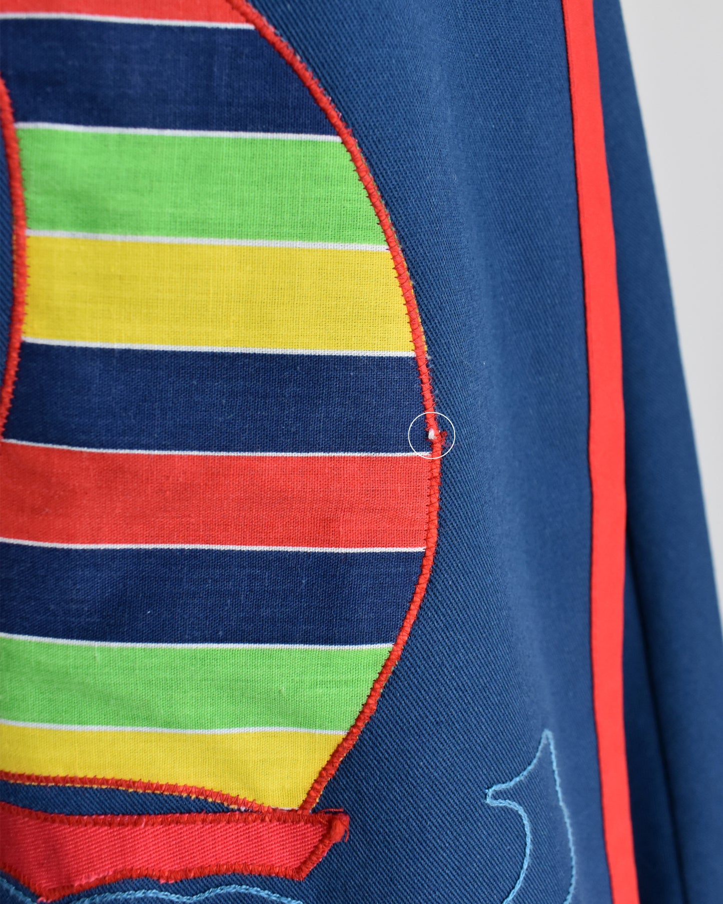 close up of the sailboat appliqué that has small pull in the thread