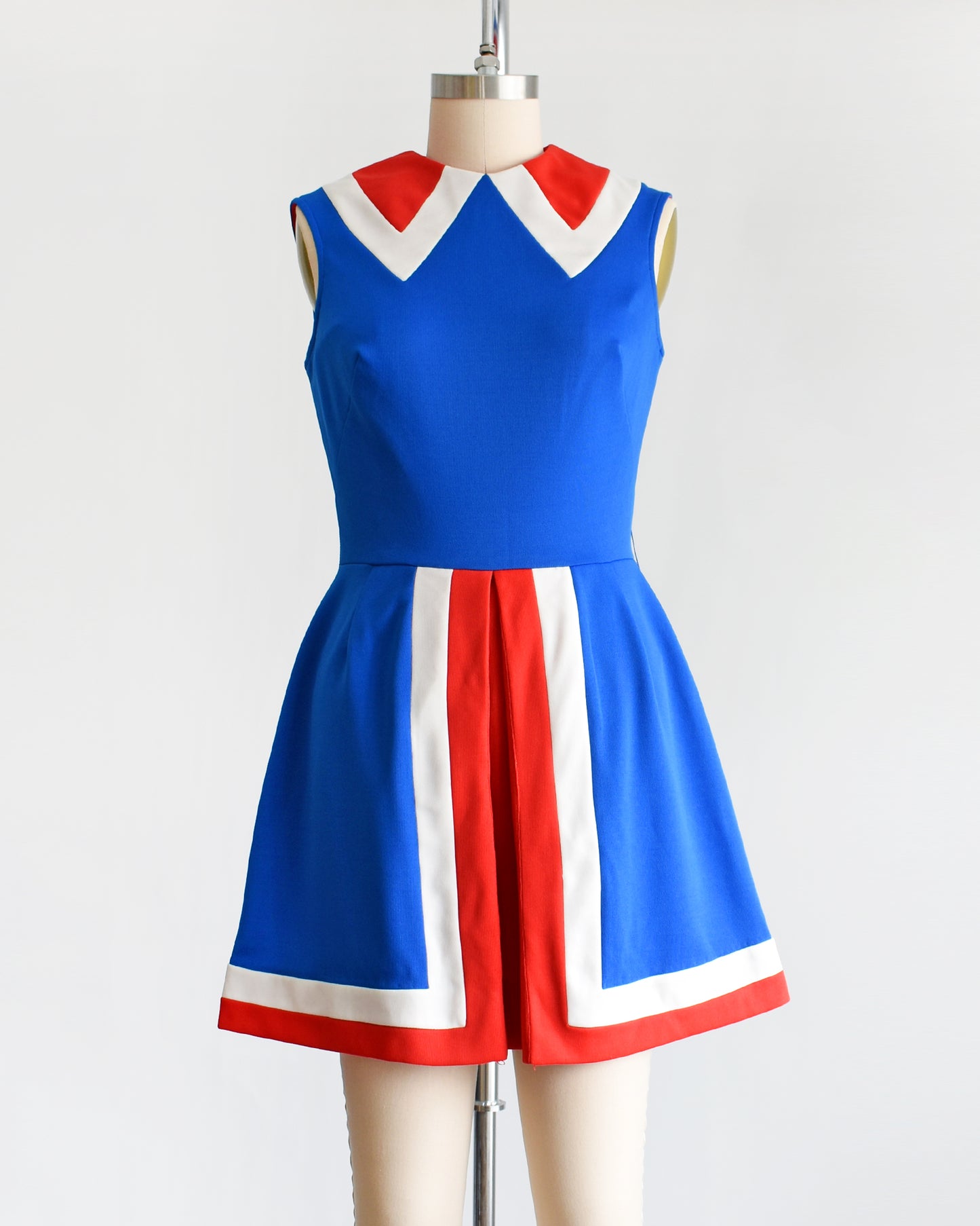 a vintage 60s/70s blue and red mod mini dress on a mannequin against a white background