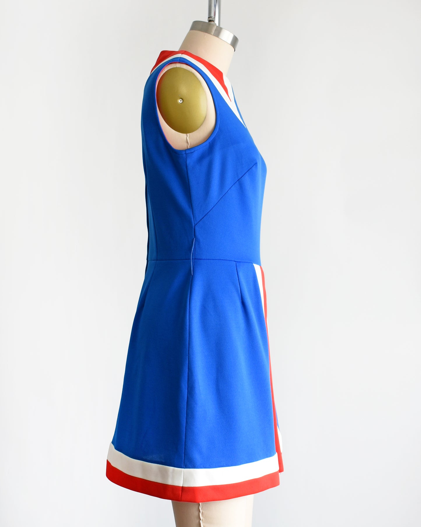 side view of a vintage 60s/70s blue and red mod mini dress on a mannequin against a white background