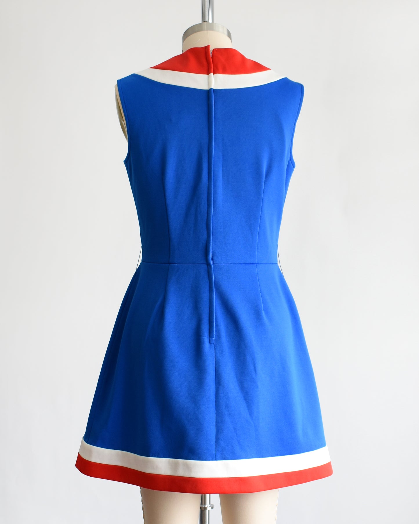back view of a vintage 60s/70s blue and red mod mini dress on a mannequin against a white background