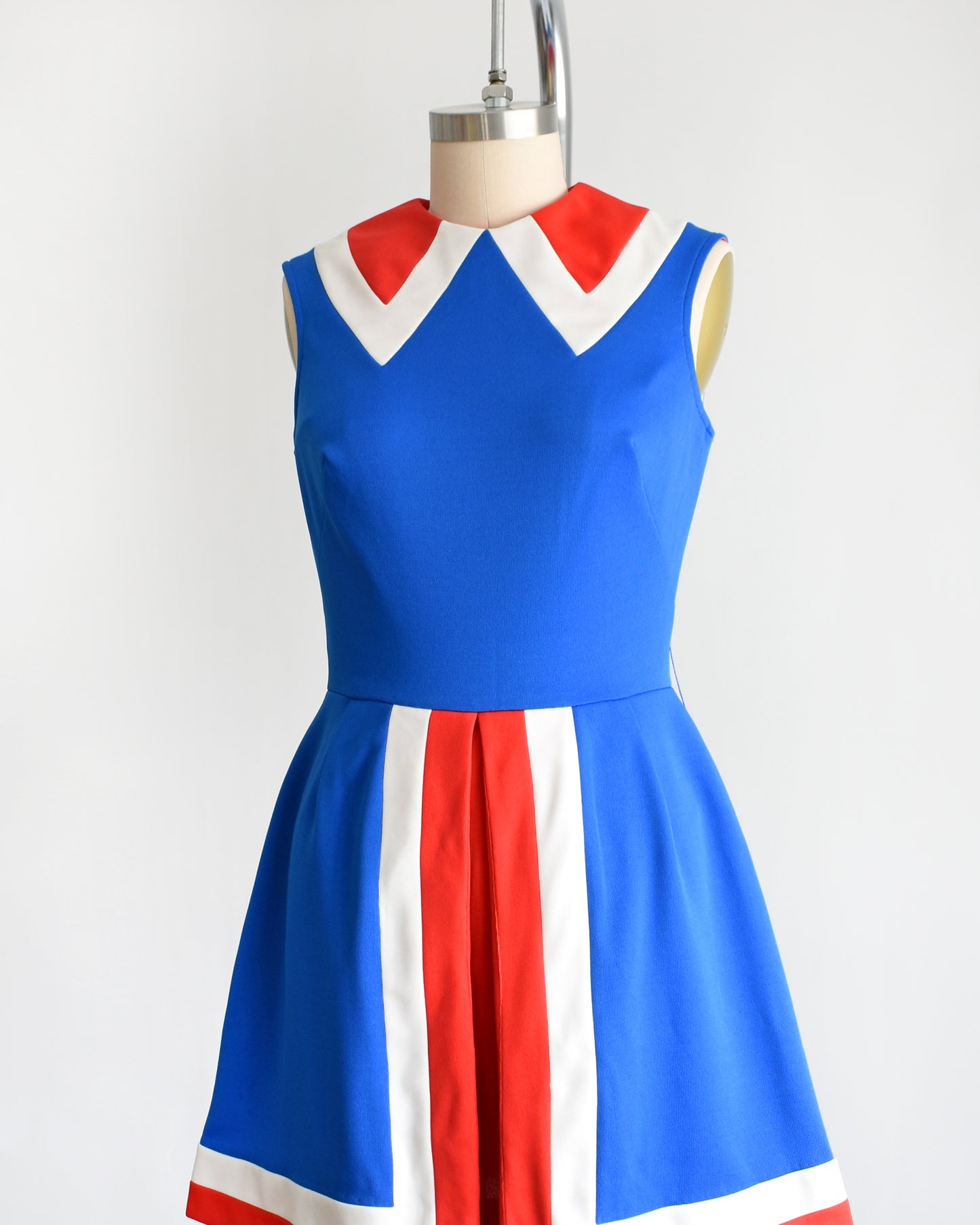 side front view of a vintage 60s/70s blue and red mod mini dress on a mannequin against a white background