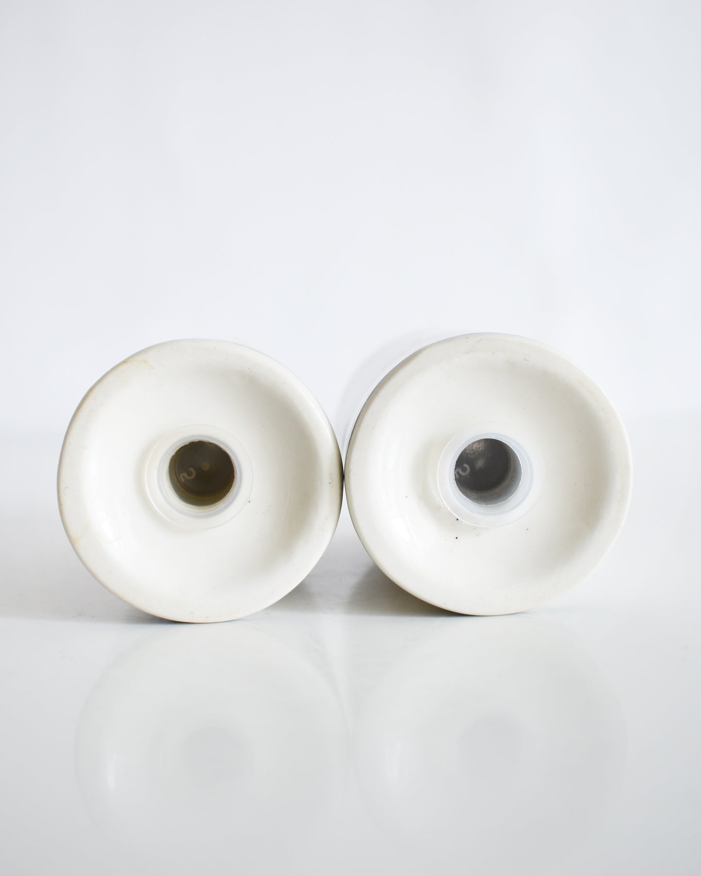 the underside of a set of ceramic Frank Lloyd Wright Martin House salt and pepper shakers on a white background