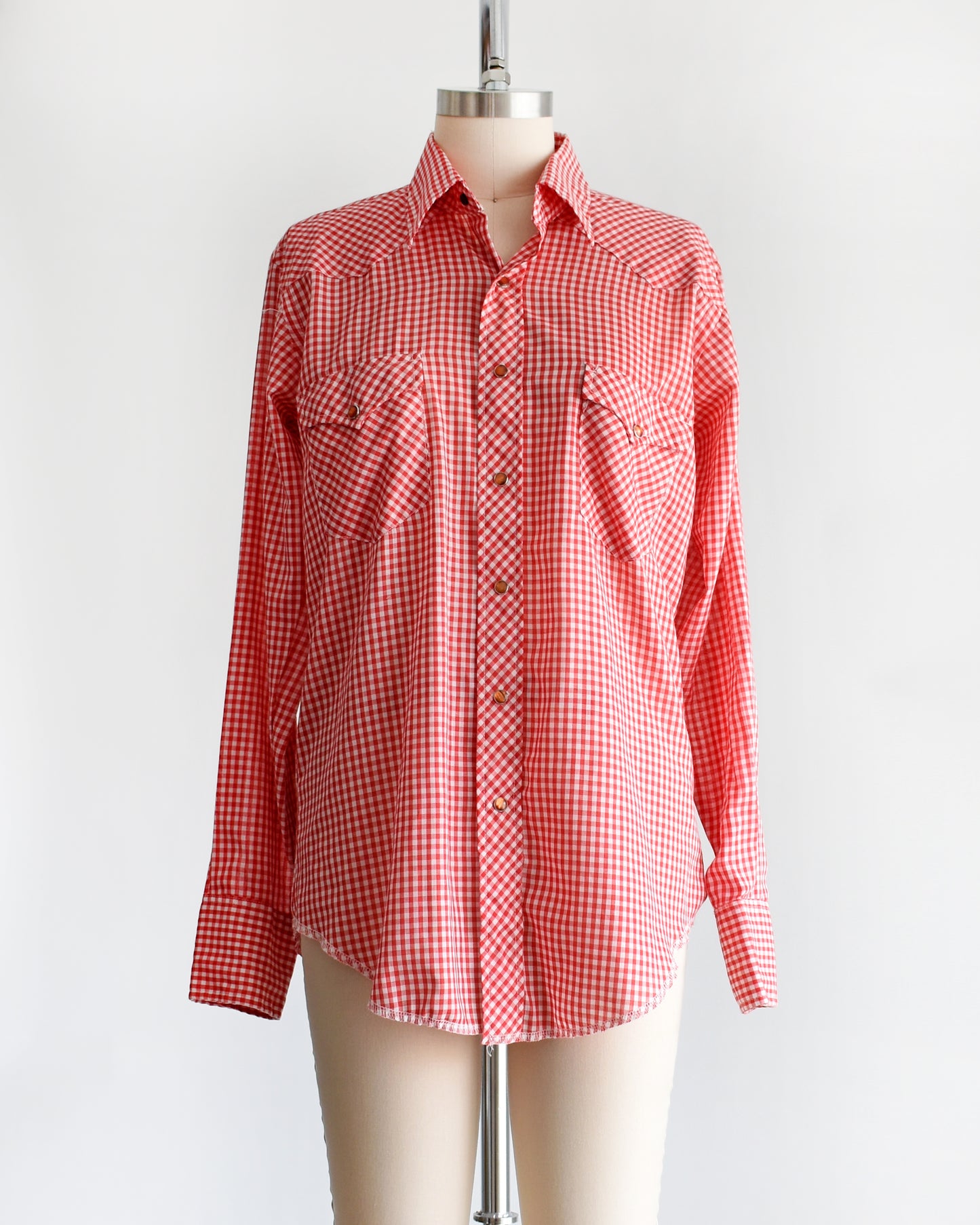 a vintage 1970s red and white gingham shirt on a mannequin against a white background