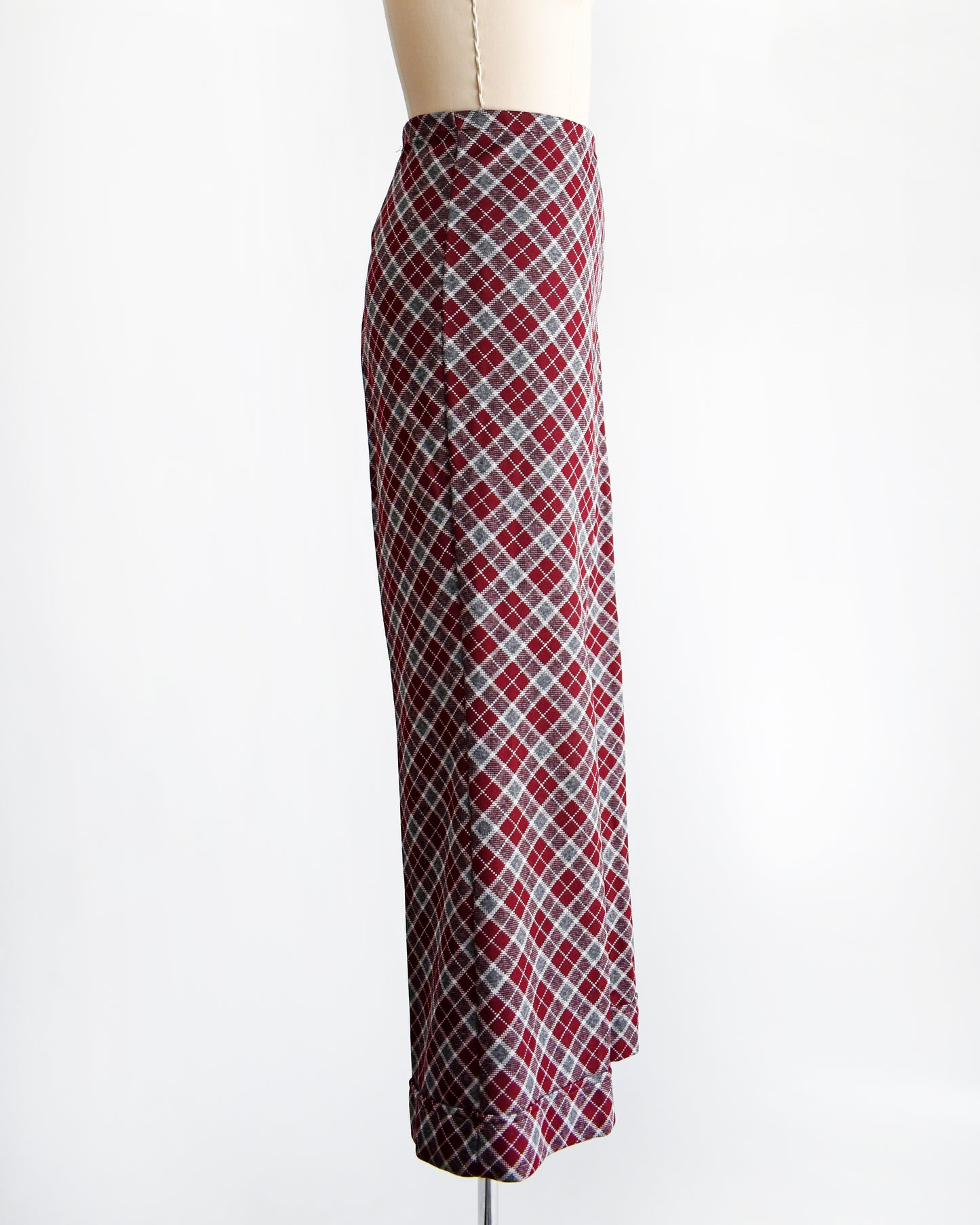 side view of a vintage 1970s burgundy plaid bell bottom pants on a mannequin against a white background