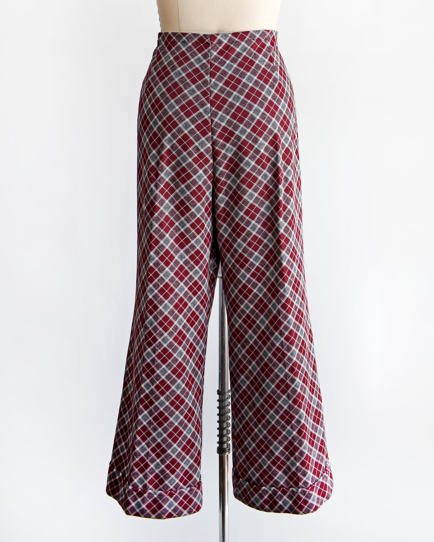 back view of a vintage 1970s burgundy plaid bell bottom pants on a mannequin against a white background