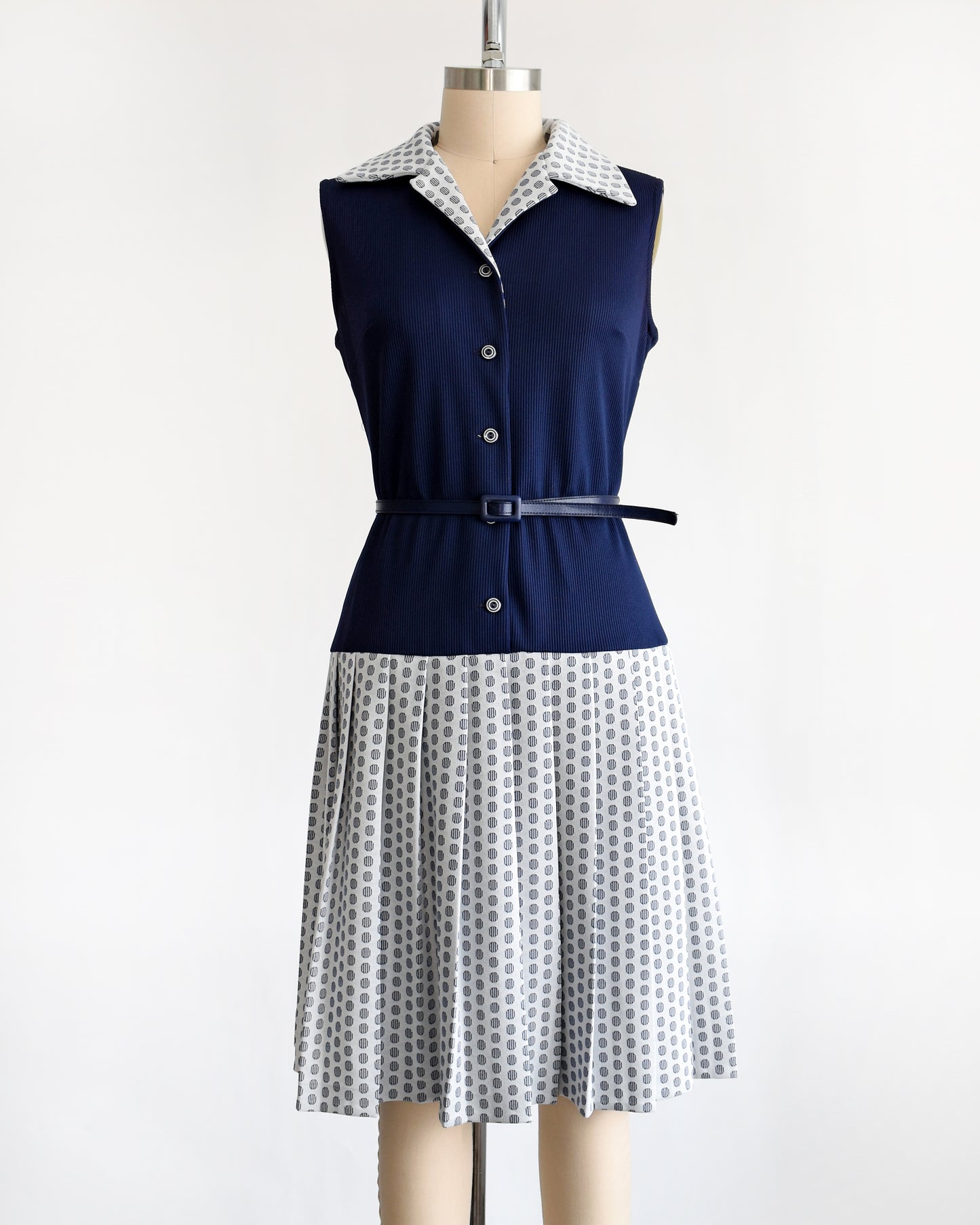 the dress of a vintage 1970s mod two piece set which features a navy blue jacket and matching dress
