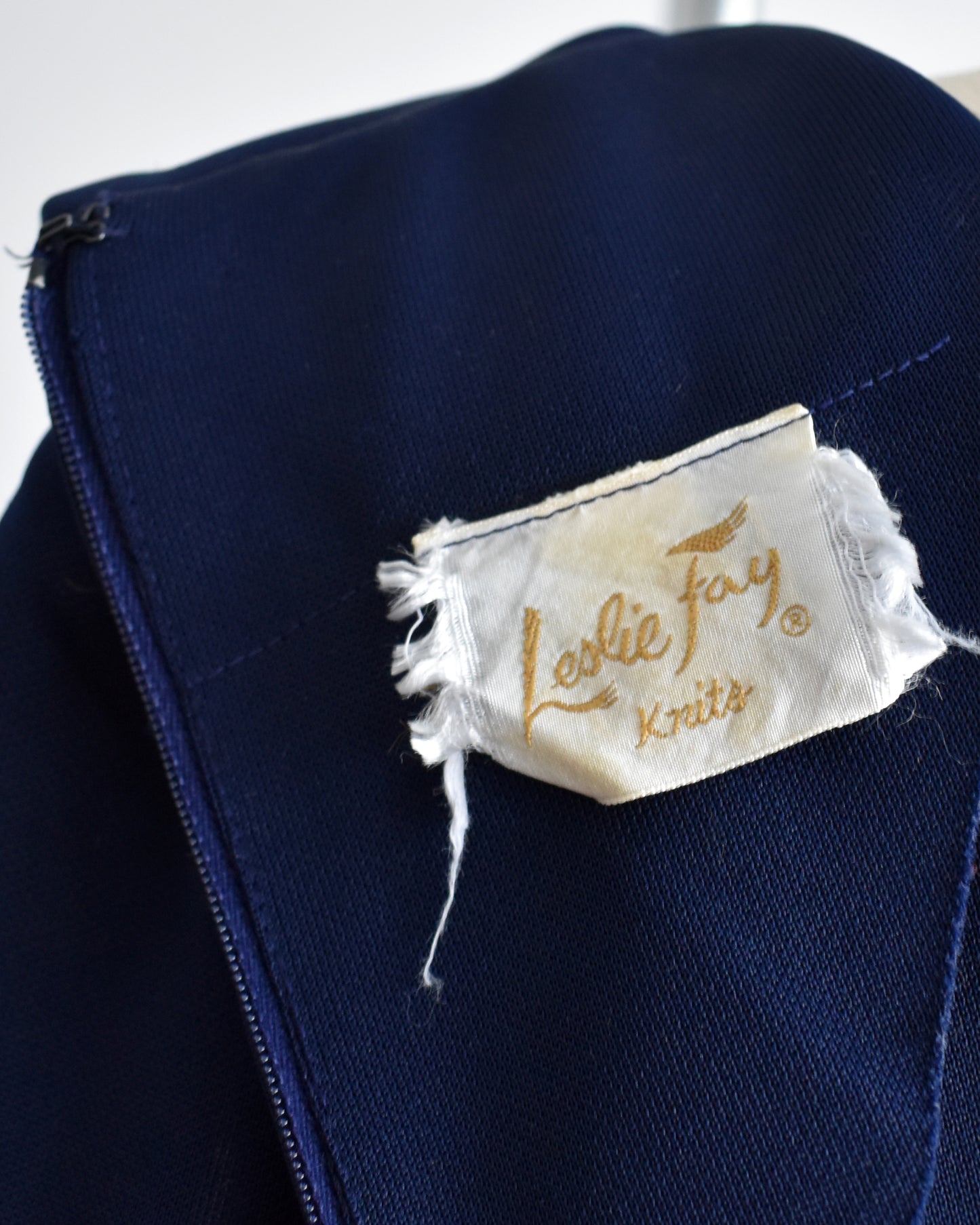 Close up of the 'Leslie Fay Knits' label on a white background