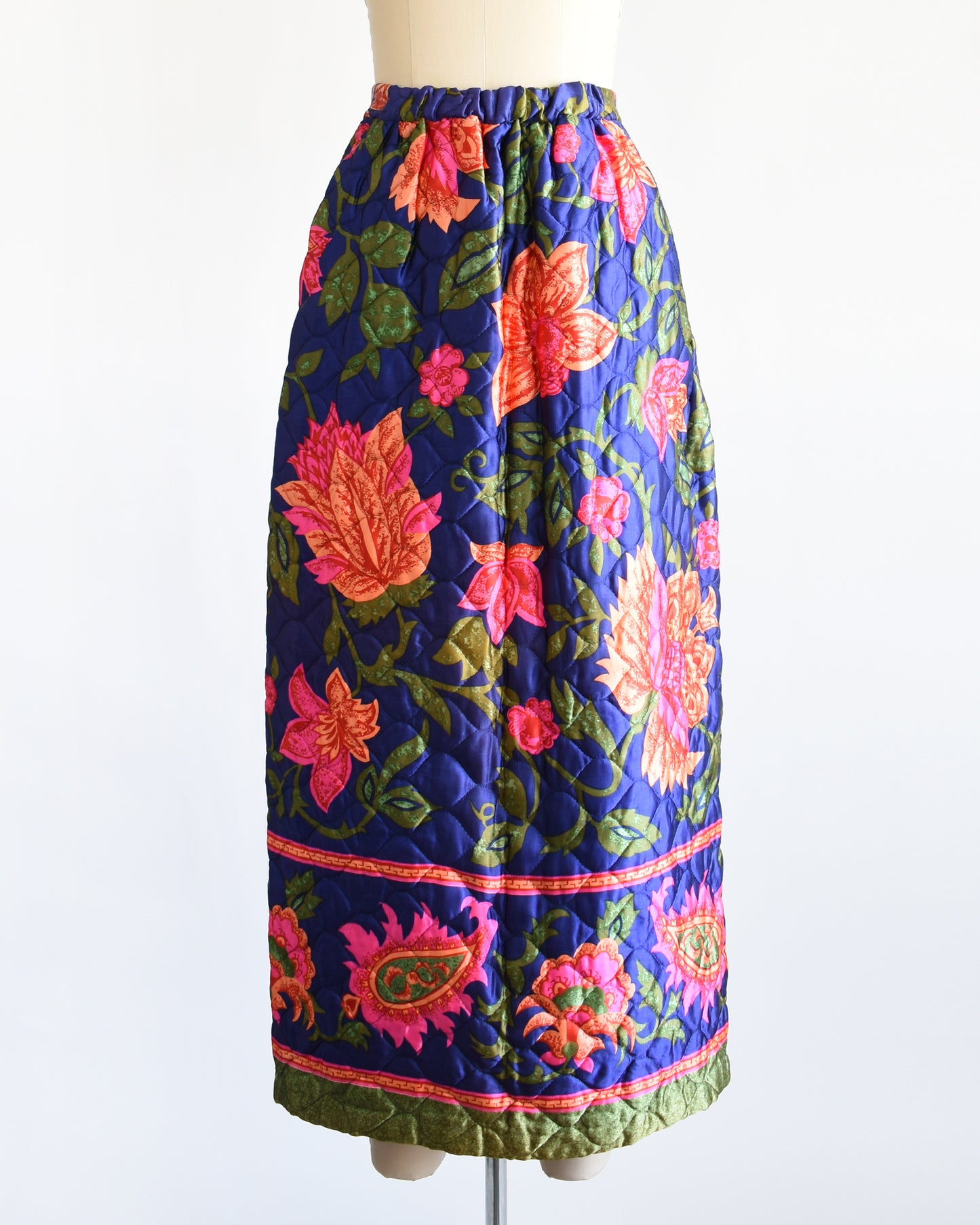 a vintage 1970s blue and pink floral patterned maxi skirt on a mannequin against a white background