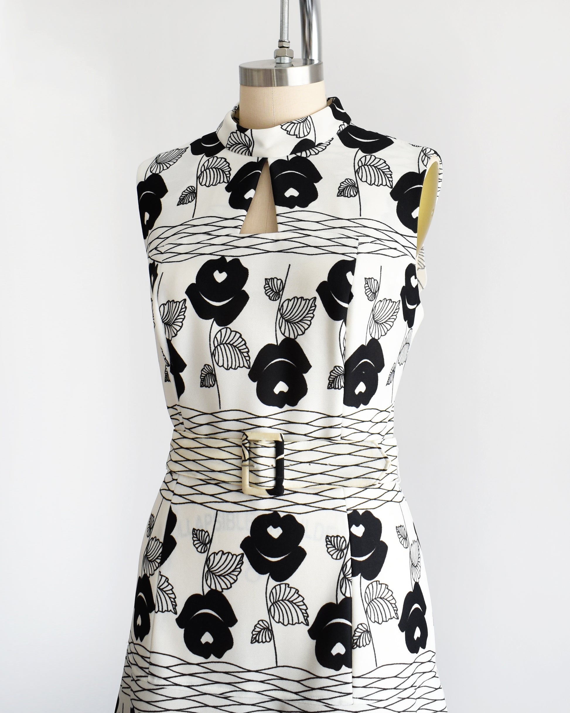 Side front view of a vintage 70s white maxi dress black floral print with wavy horizontal lines with matching belt.