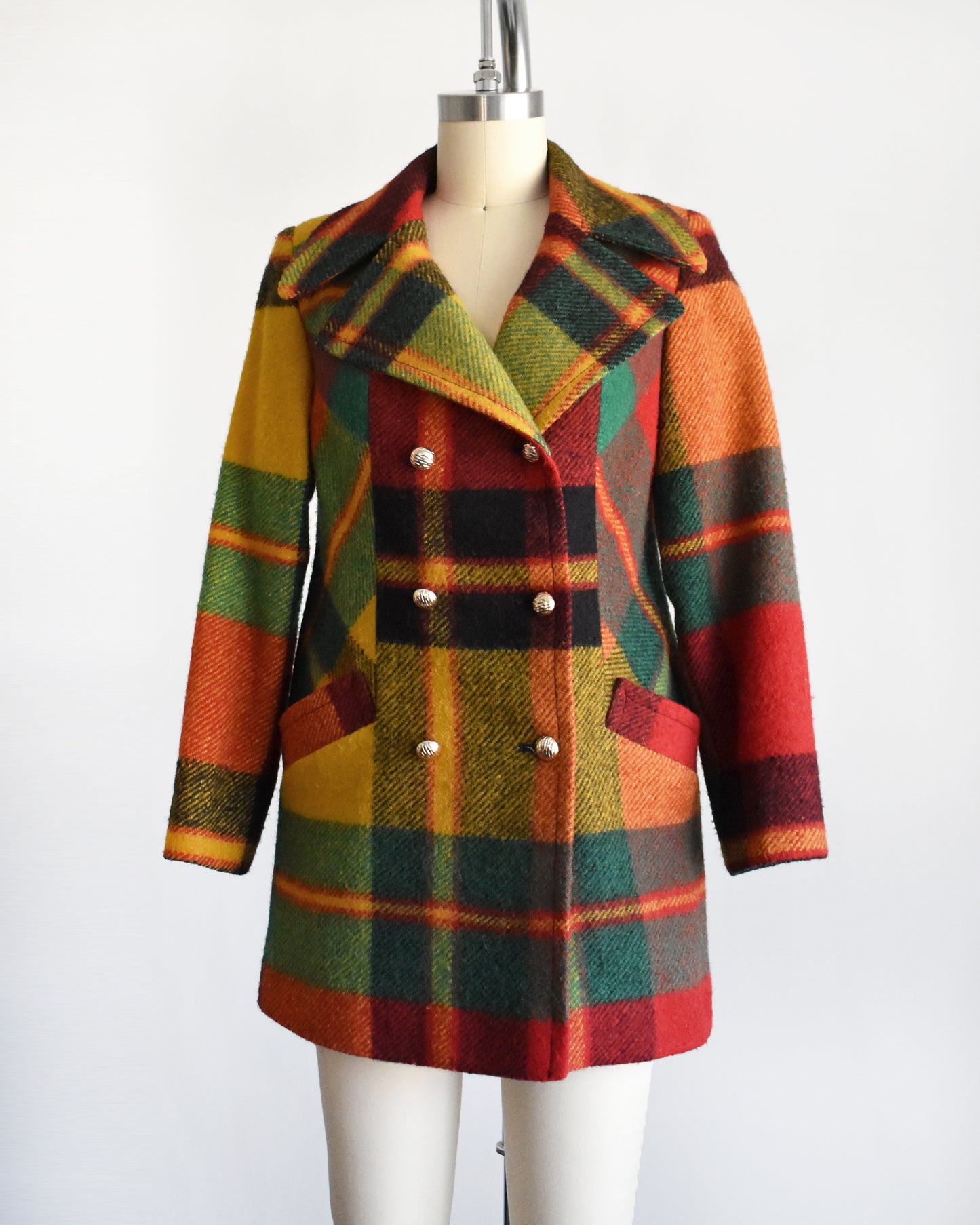 side front view of a vintage 1970s rainbow plaid coat on a mannequin against a white background