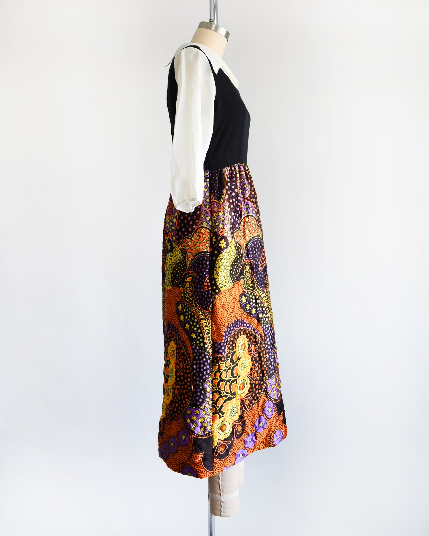 side view of a vintage 1970s psychedelic quilted maxi dress on a mannequin against a white background