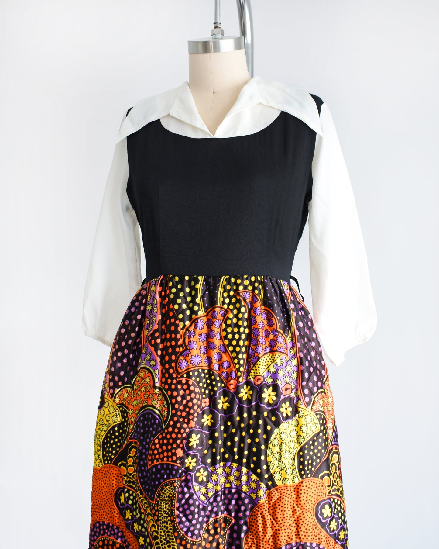 side front view of a vintage 1970s psychedelic quilted maxi dress on a mannequin against a white background