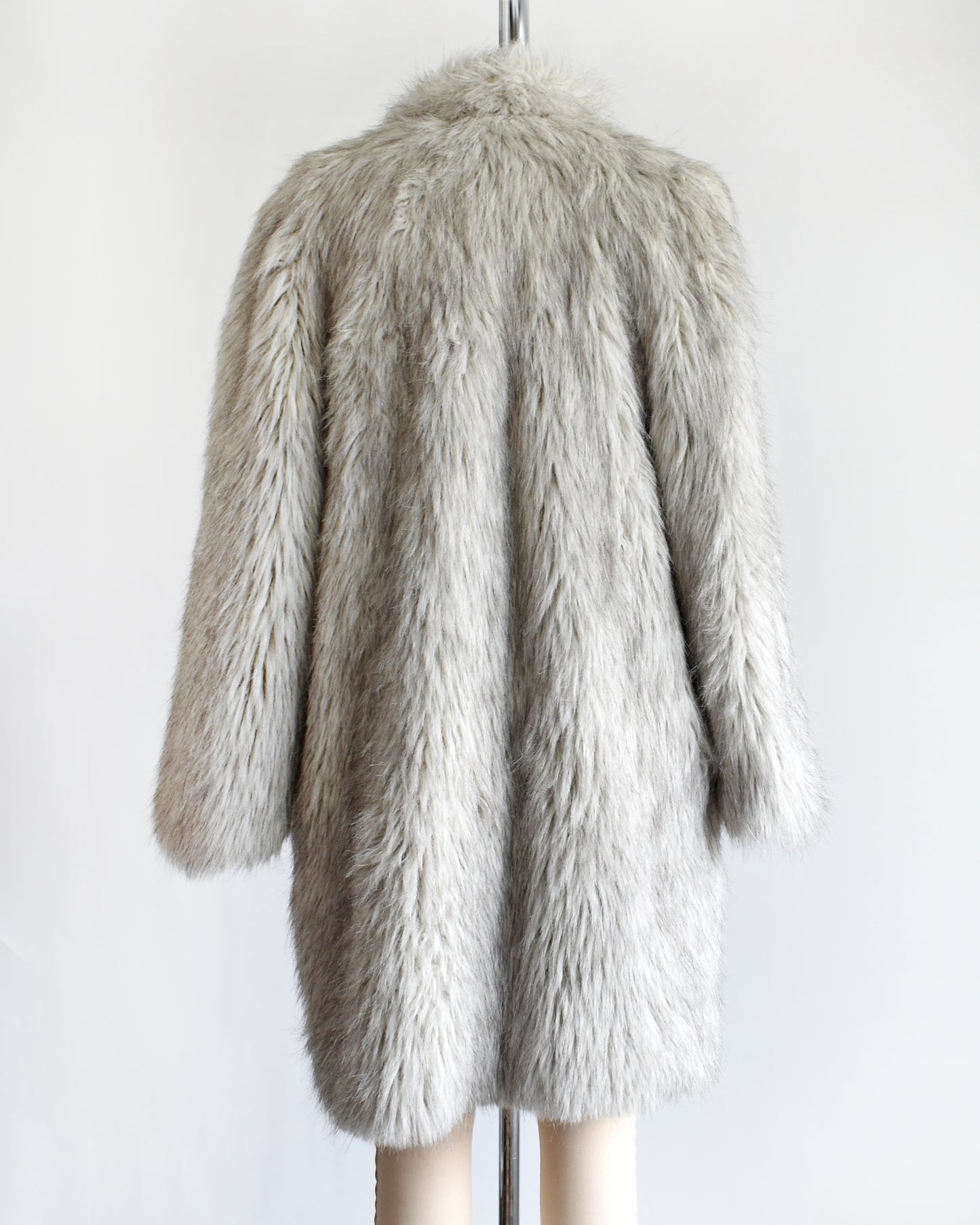 back view of a vintage 1980s faux fur silver fox coat on a dress form on a white background