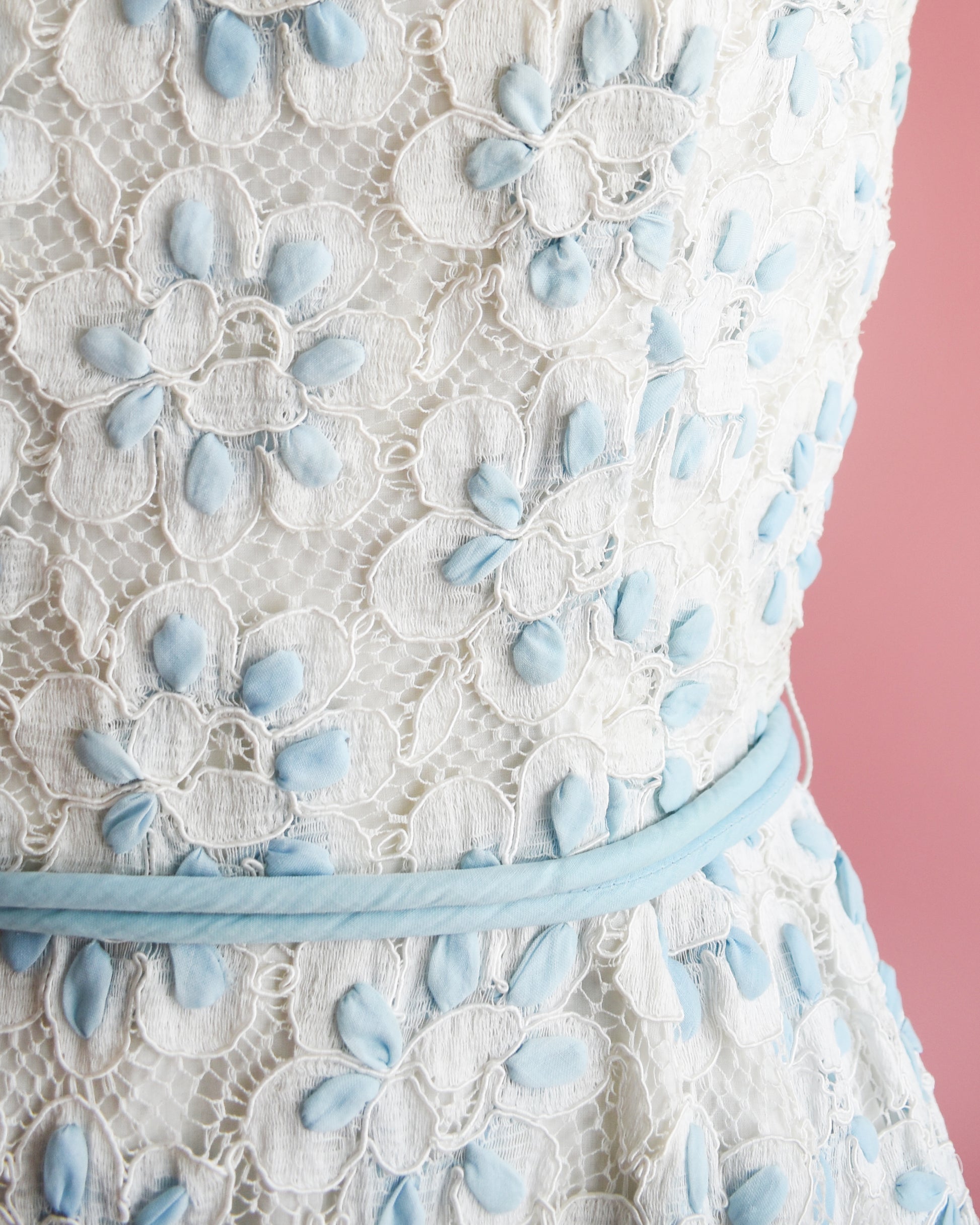 Close up of the waist, floral detail, and rope belt.
