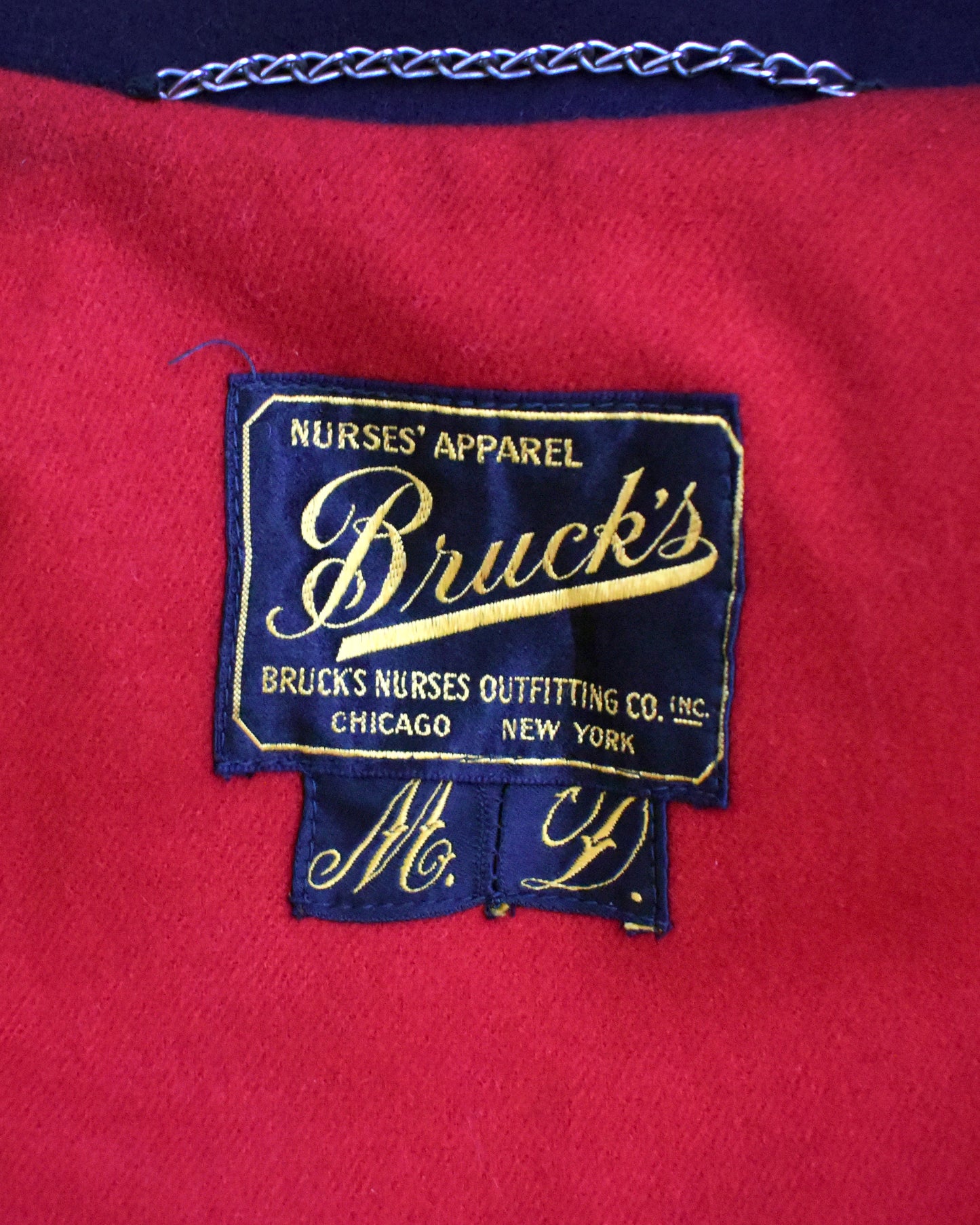 close up of the Bruck's Nurses Apparel label on a red background