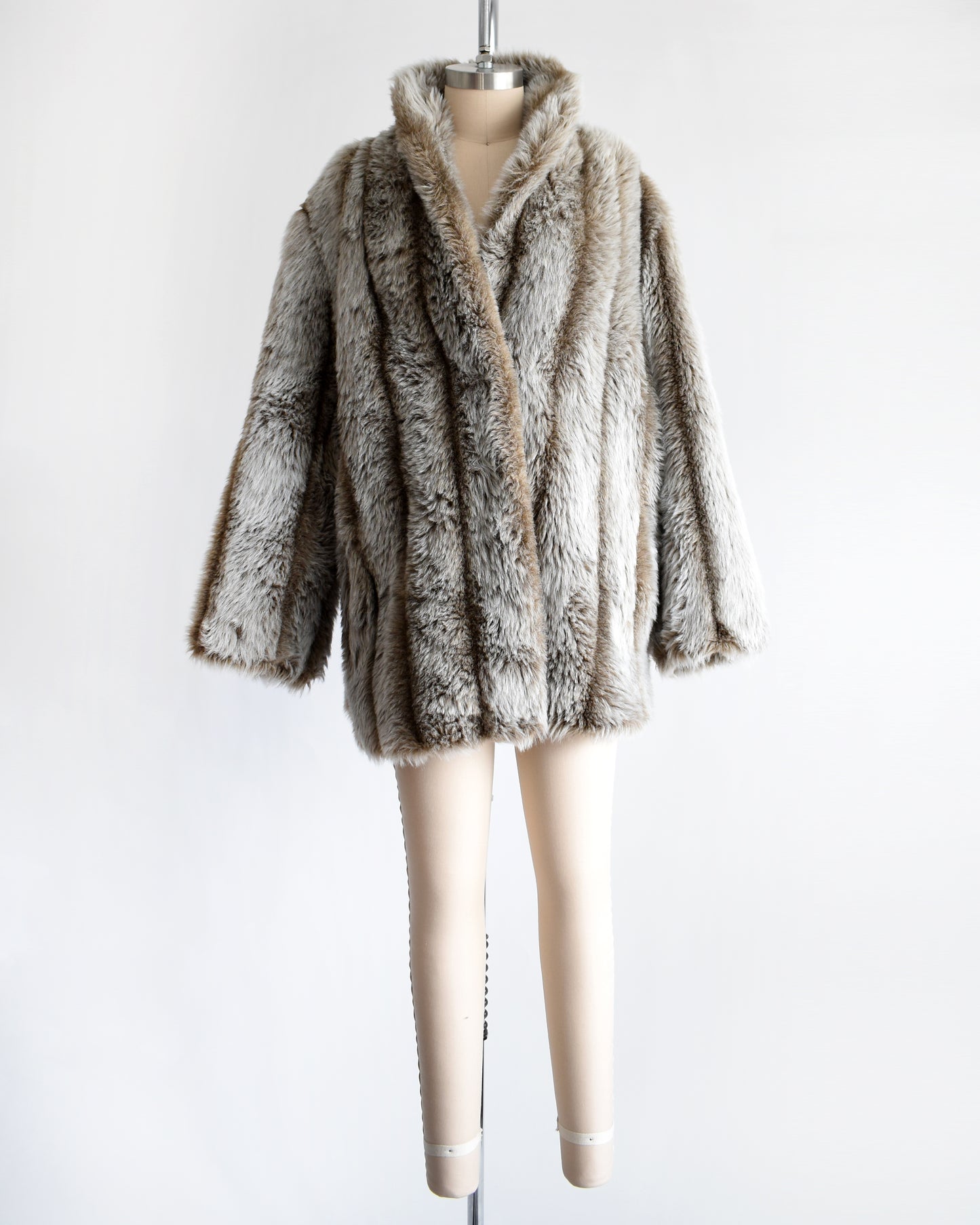 a vintage 1980s brown and gray faux fur coat on a mannequin against a white background