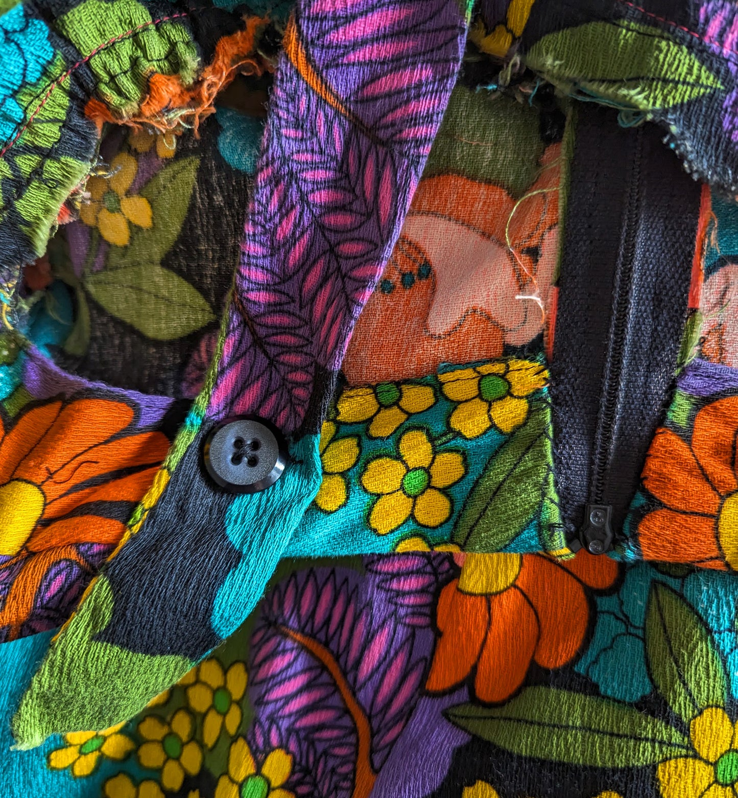 Close up of one of the back button, zipper, and strap.