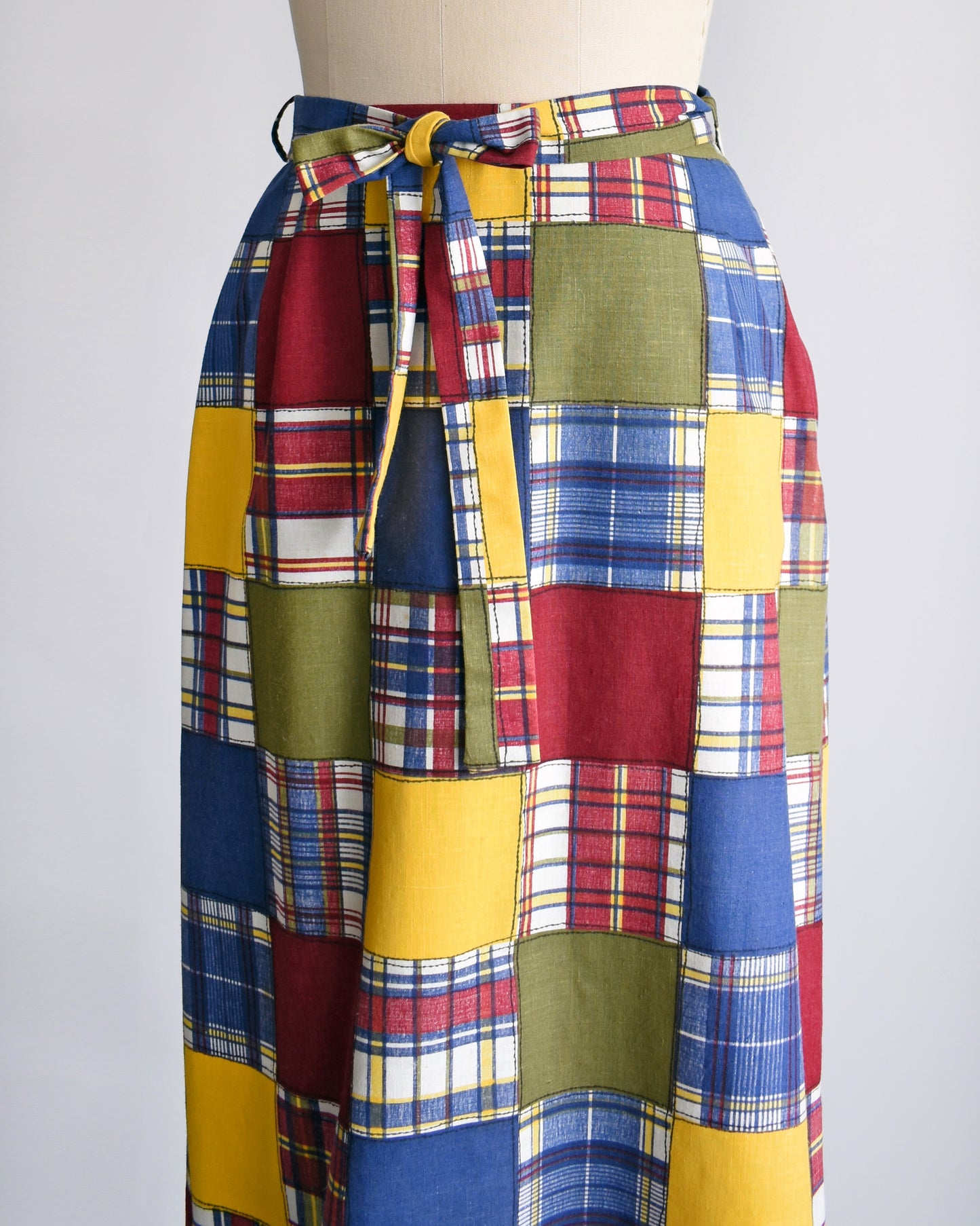 side front view of a vintage 1970s patchwork madras plaid maxi skirt with matching tie belt