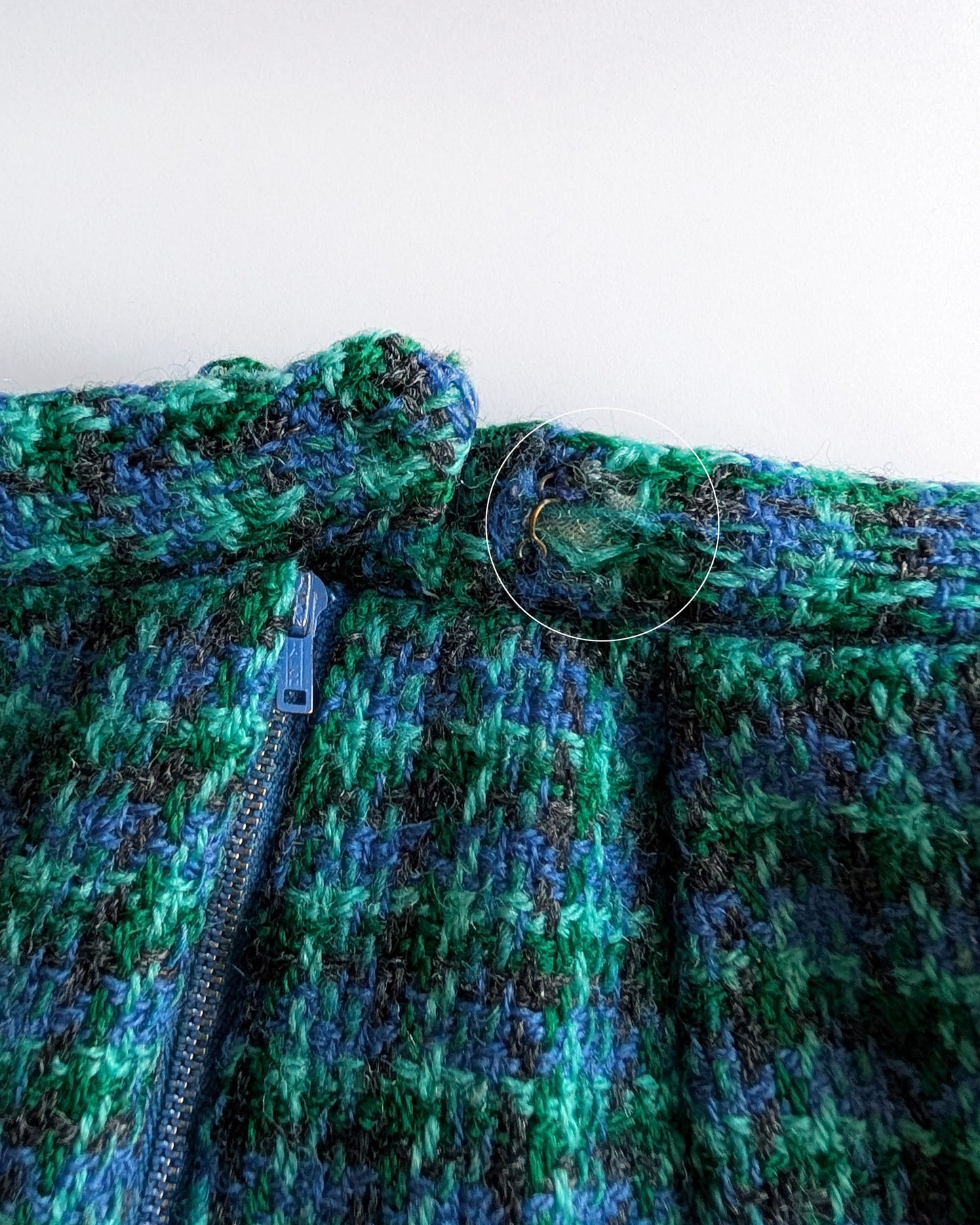 close up of a small flaw on the waist which shows a small bit of wool missing which shows the inner waistband.