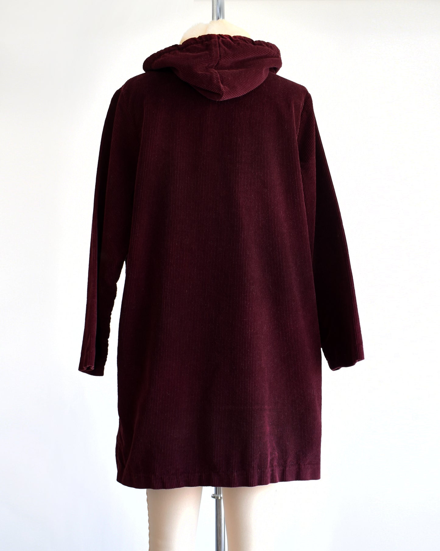 back view of a vintage 1970s burgundy corduroy jacket with a sherpa lined hood on a dress form