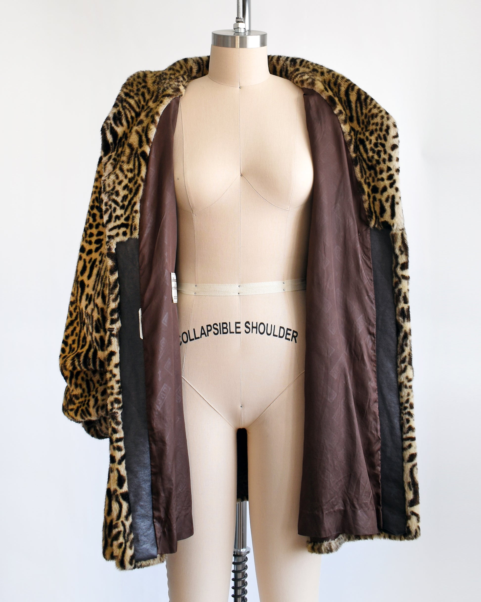 a vintage 1970s faux fur leopard print coat that's opened showing the brown lining