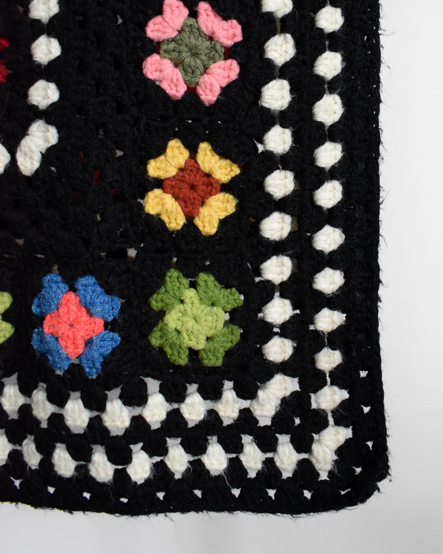 close up of the black and white crochet and granny square blanket