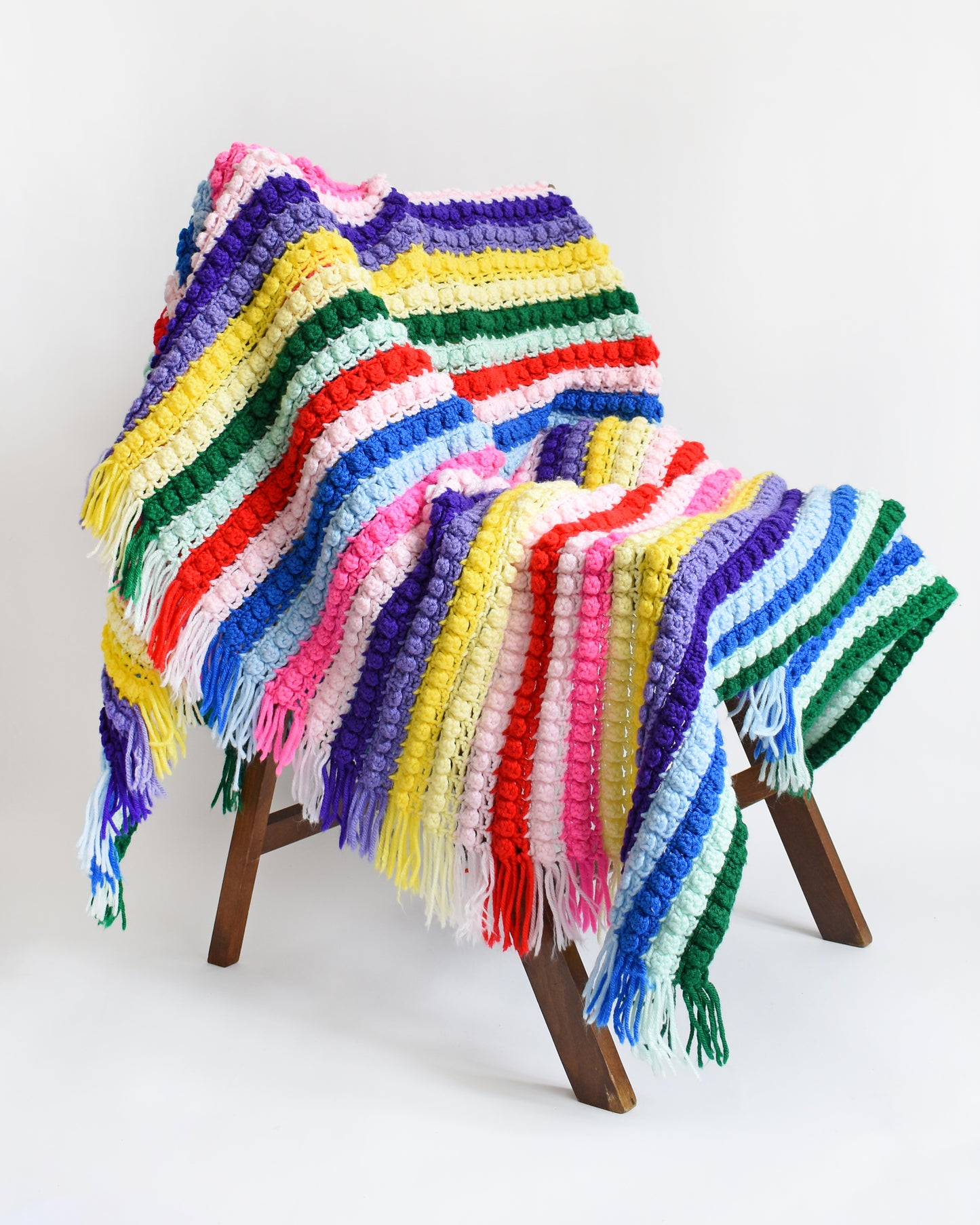 a vintage rainbow striped blanket draped on a chair