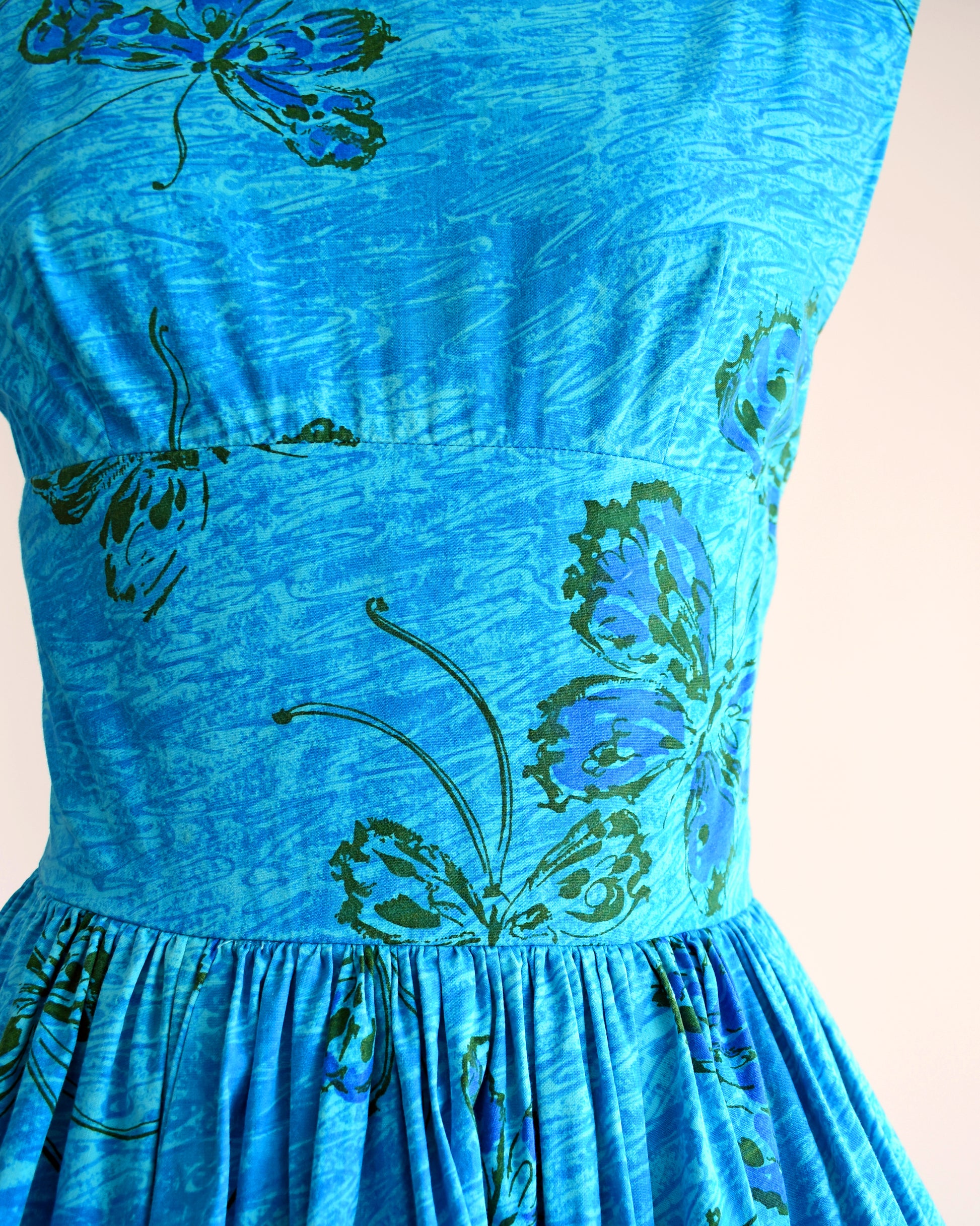 Close up of the bodice of the vintage 1950s dress which shows the swirl and butterfly pattern