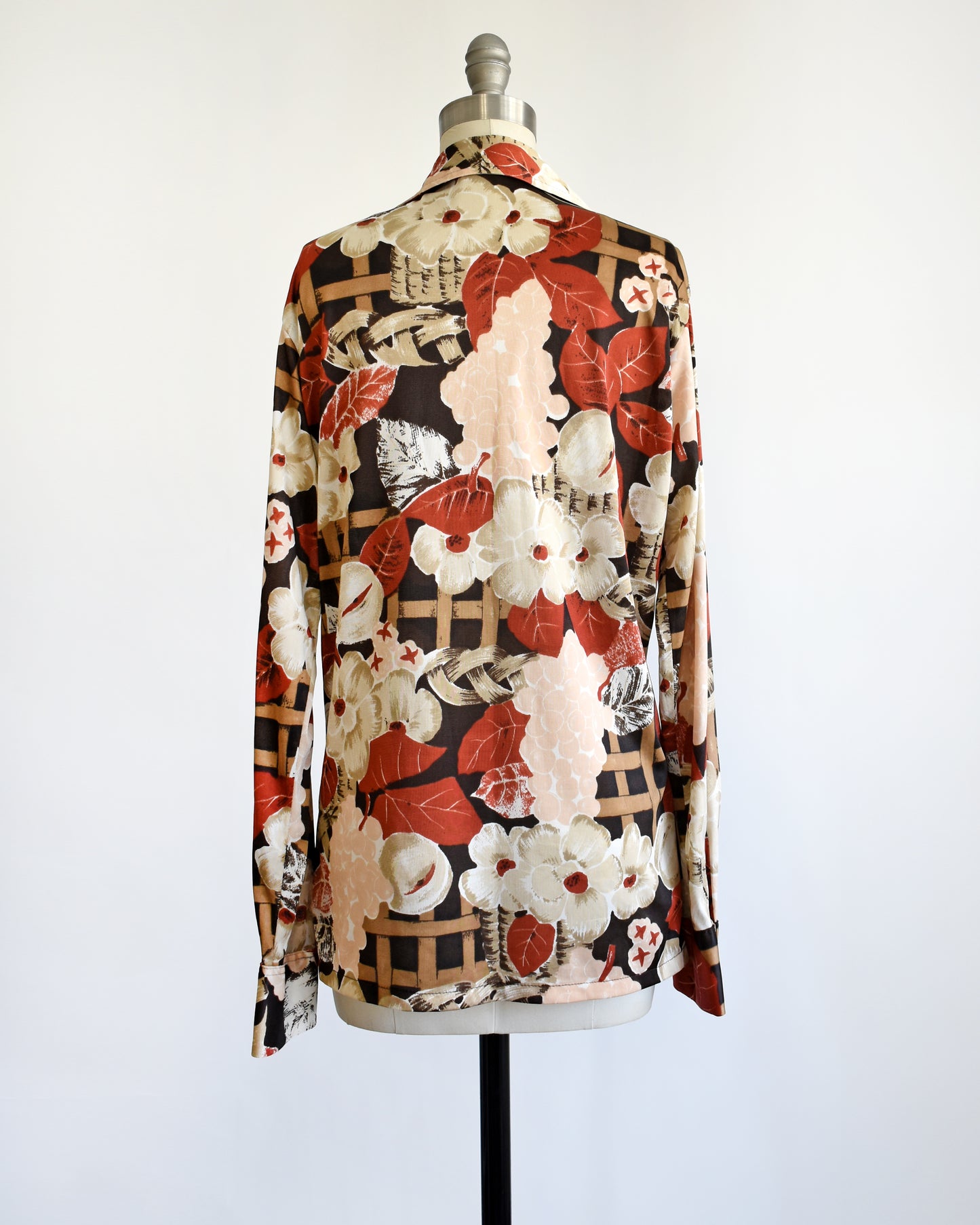 back view of a vintage 1970s fruit and florals disco shirt on a dress form