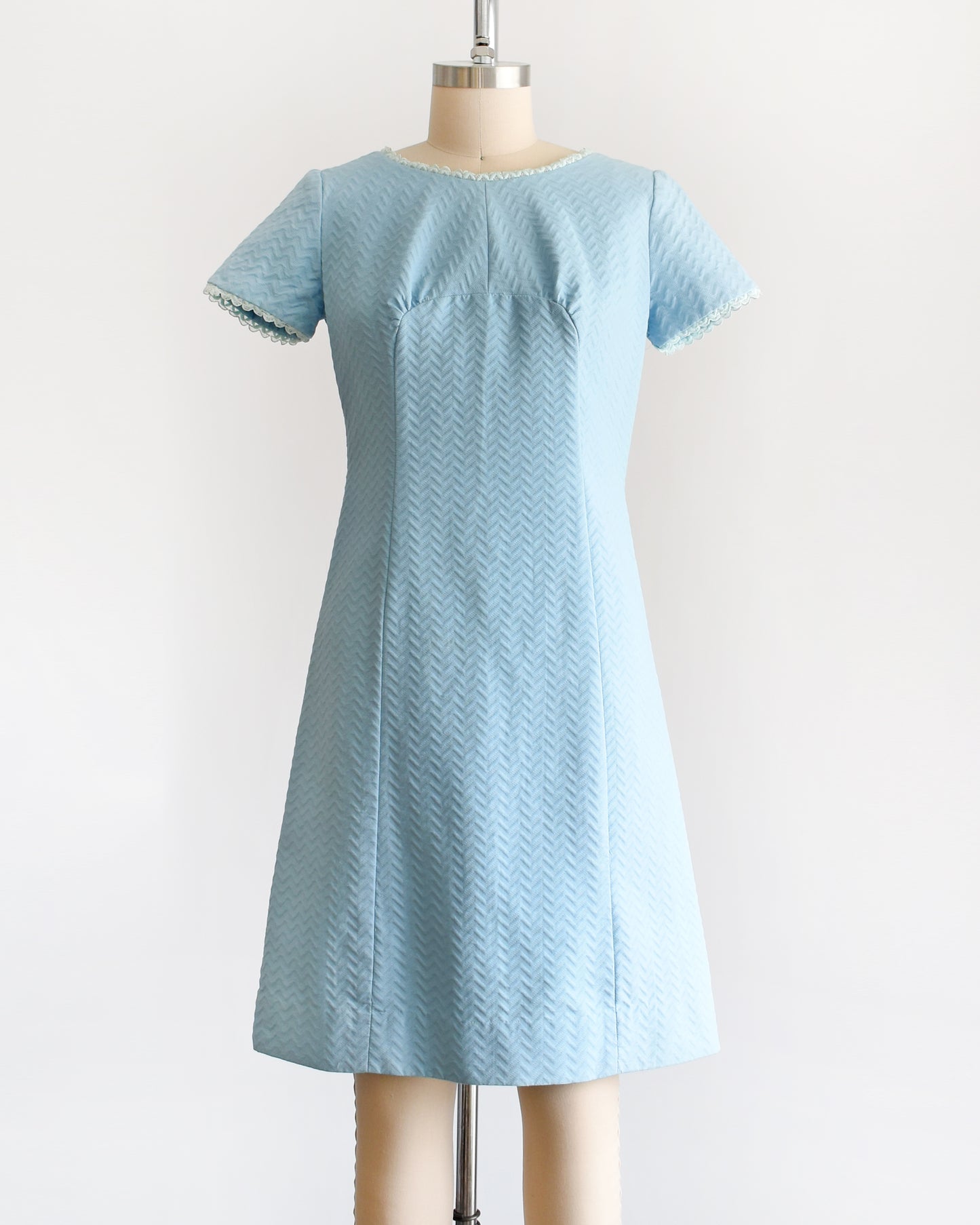 A vintage 1960s mod dress that has textured light blue chevron striped knit with alternating ribbing.
