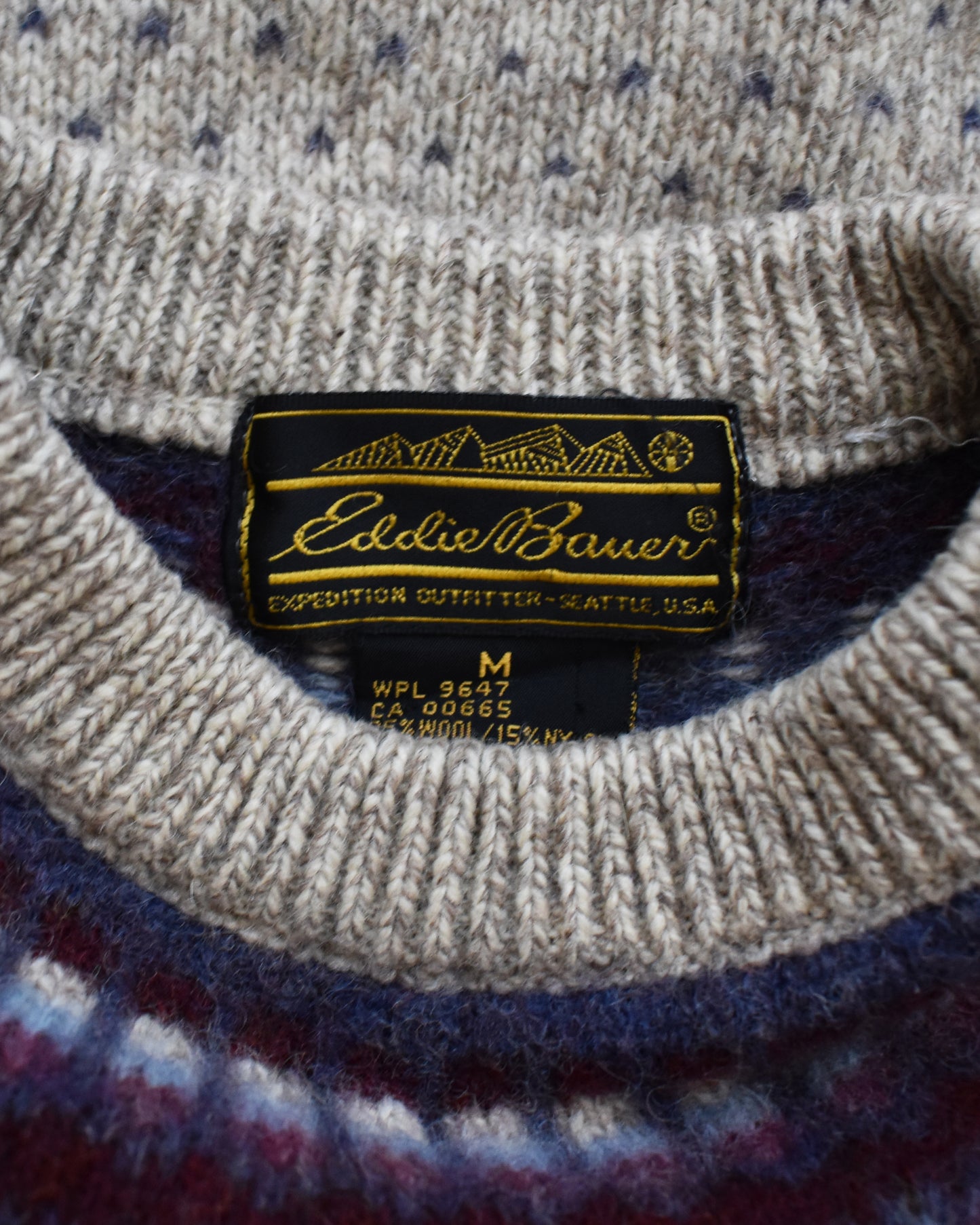 Close-up of Eddie Bauer label on a sweater with a patterned background