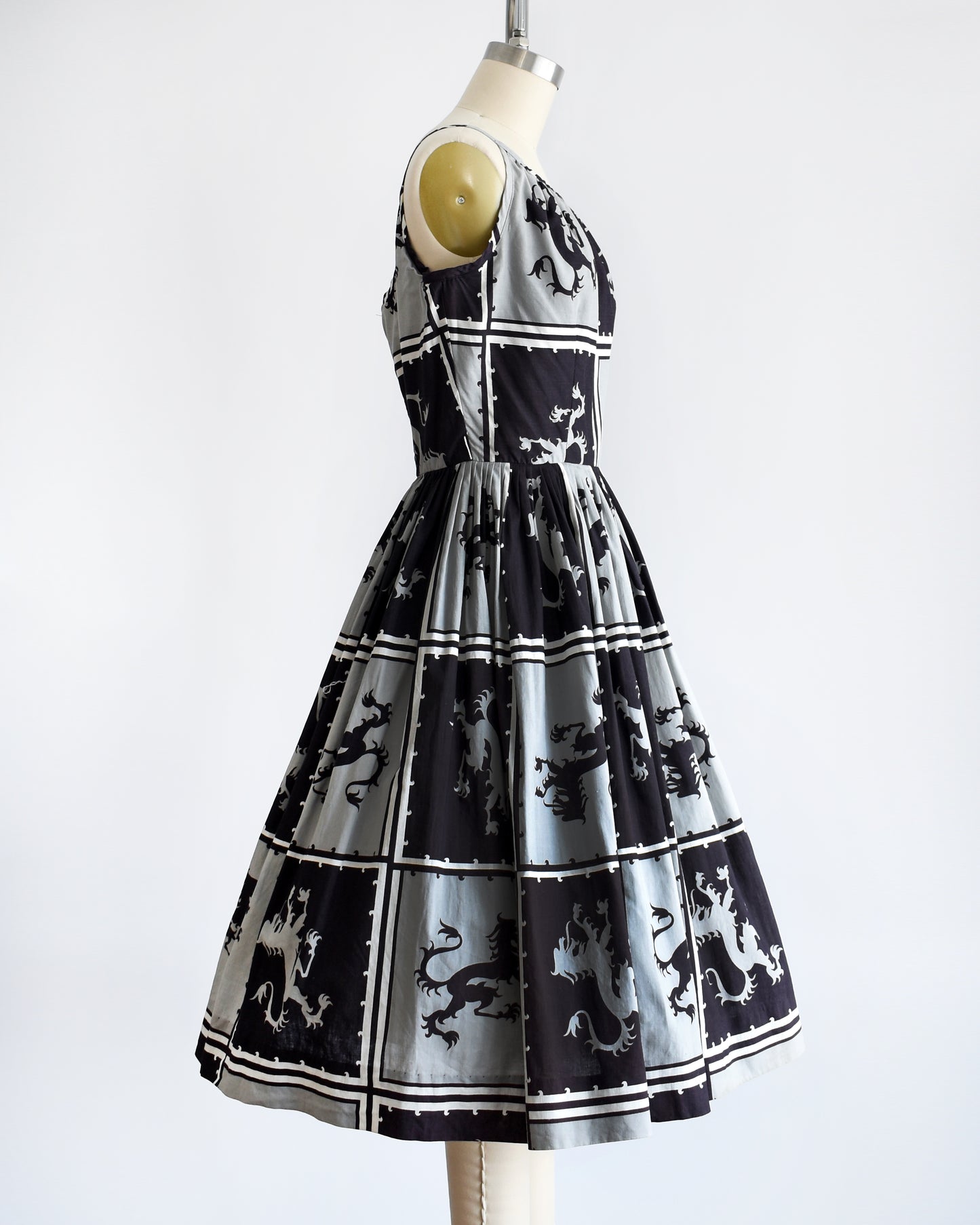 Side view of a vintage 1950s that has a black and light gray checkered pattern with a Scottish lion in each center, framed by black and white stripes.