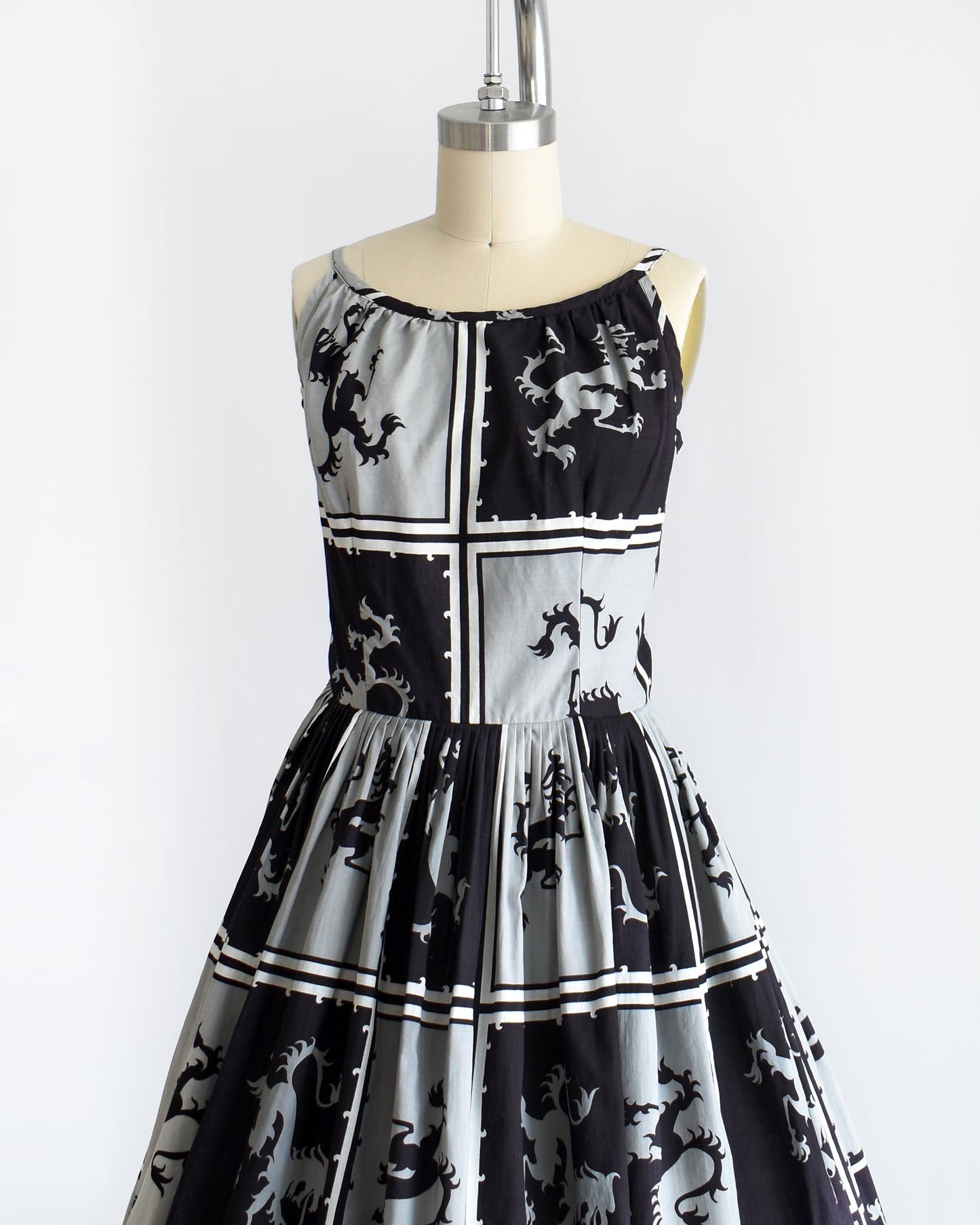 Side front view of a vintage 1950s that has a black and light gray checkered pattern with a Scottish lion in each center, framed by black and white stripes.