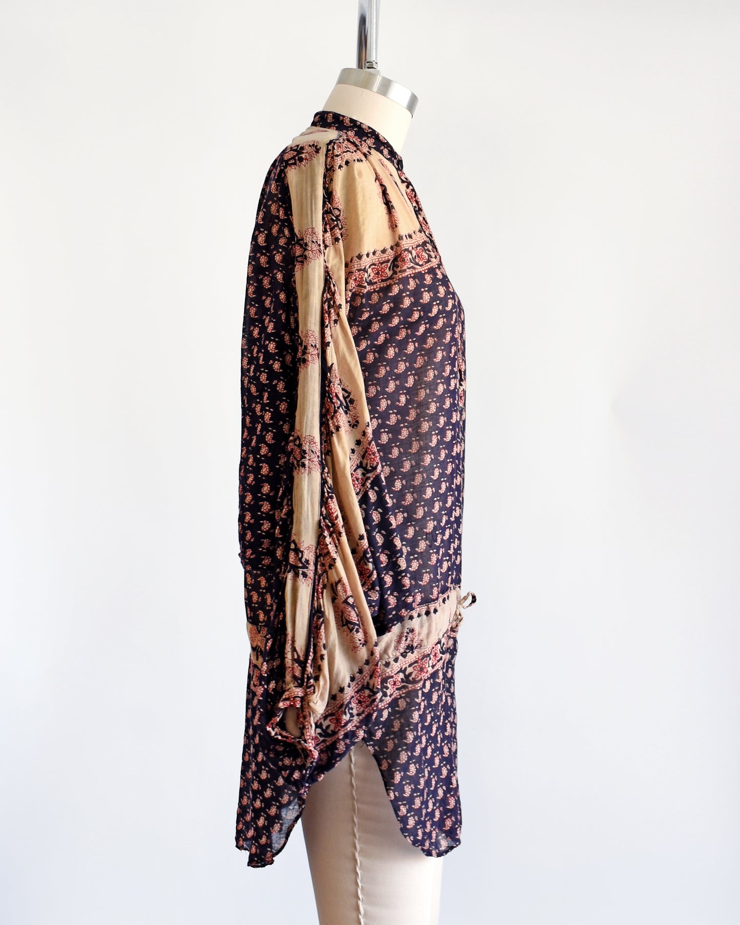 Side view of a vintage 1970s Indian cotton tunic made from thin, gauzy navy blue and light tan cotton with a red and navy floral block print