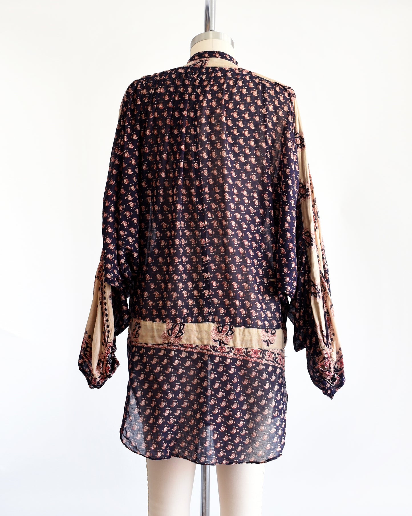 Back view of a vintage 1970s Indian cotton tunic made from thin, gauzy navy blue and light tan cotton with a red and navy floral block print