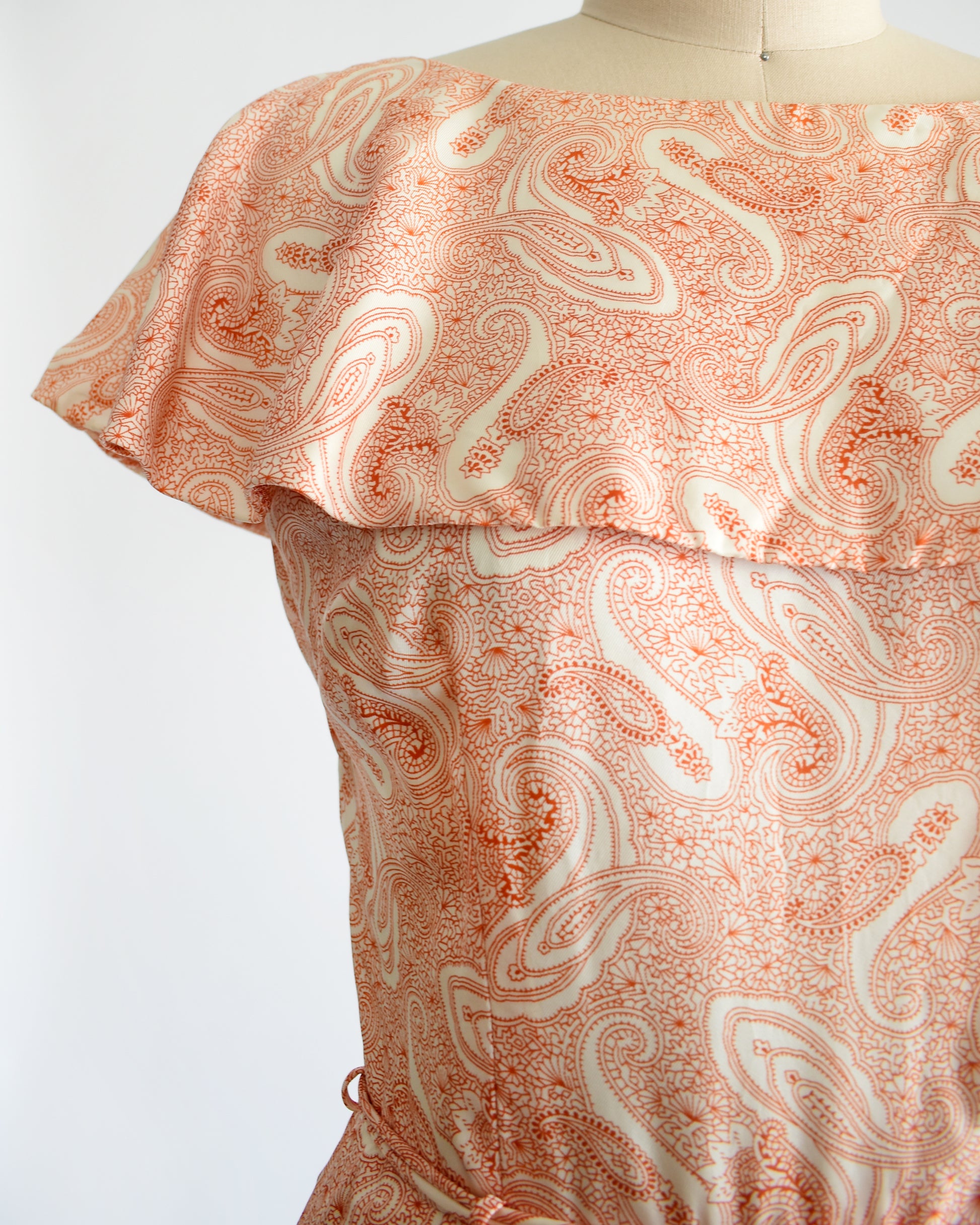 Close up of the ruffled neckline and paisley print
