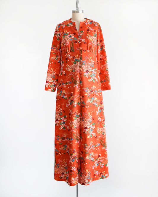 A vintage 1970s maxi dress features a vibrant red-orange hue, with a delightful floral and dotted print in homage to traditional Japanese flower designs. 