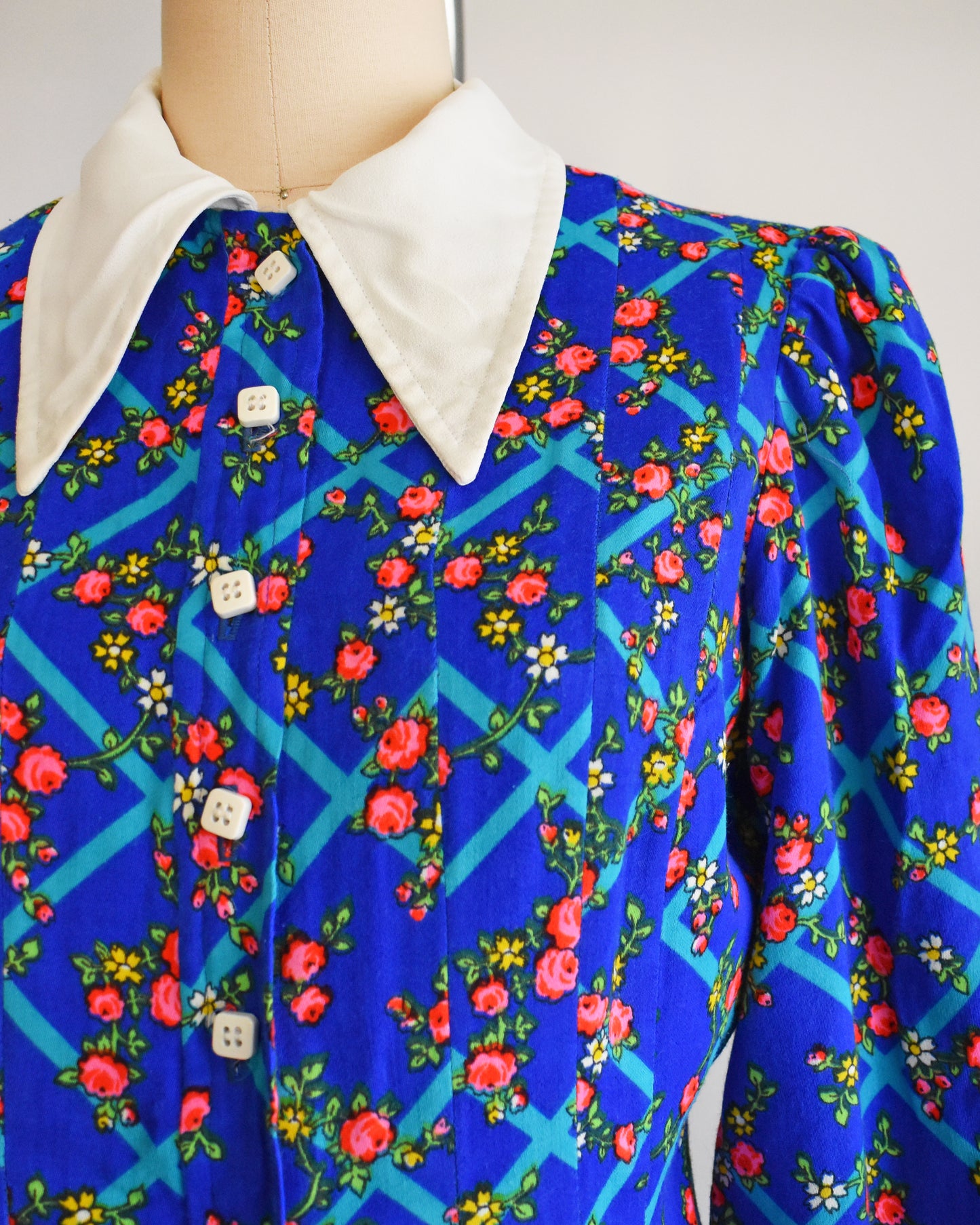 Close up of the collar, floral print, and white buttons