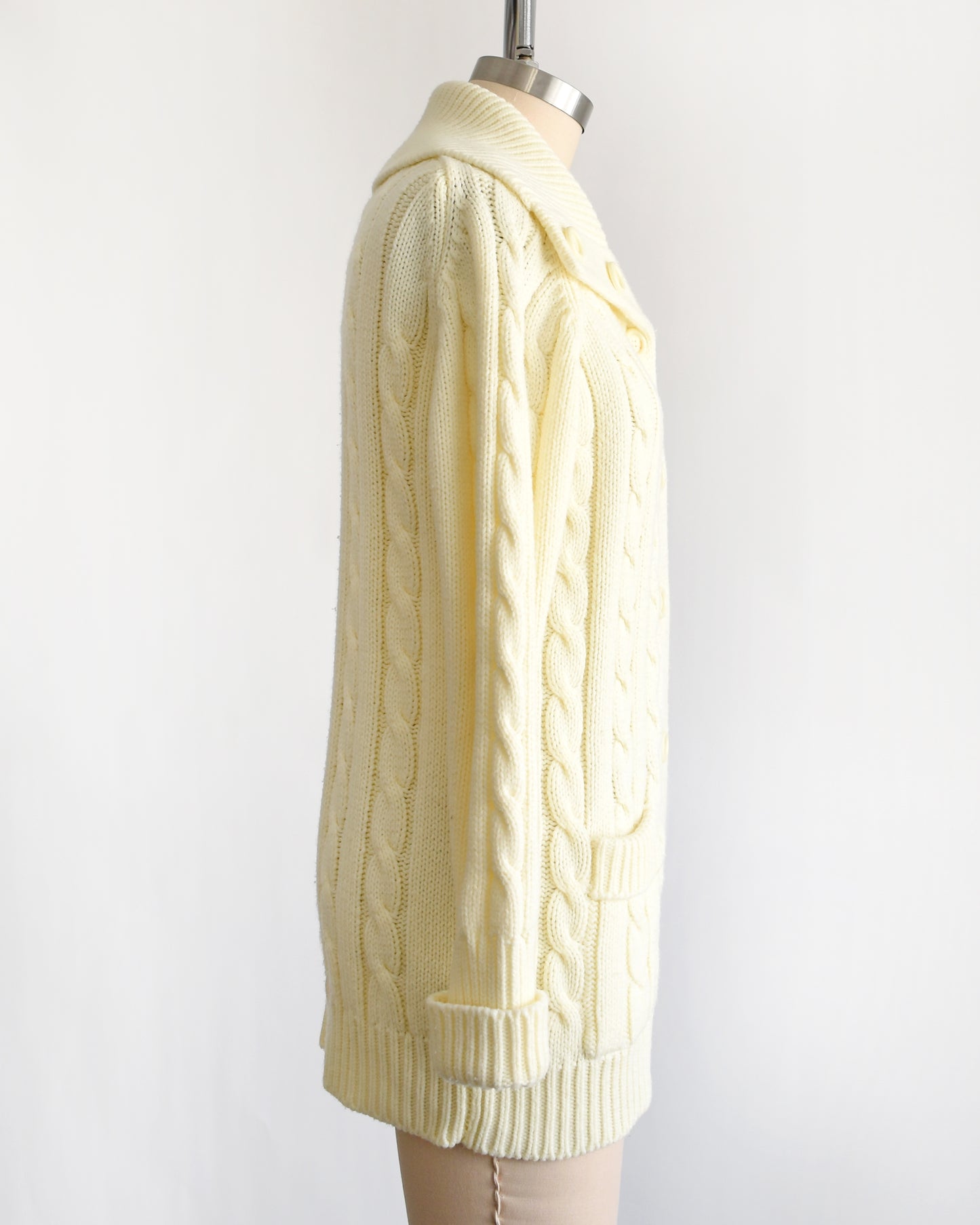 side view of a vintage 1970s cream cable knit cardigan