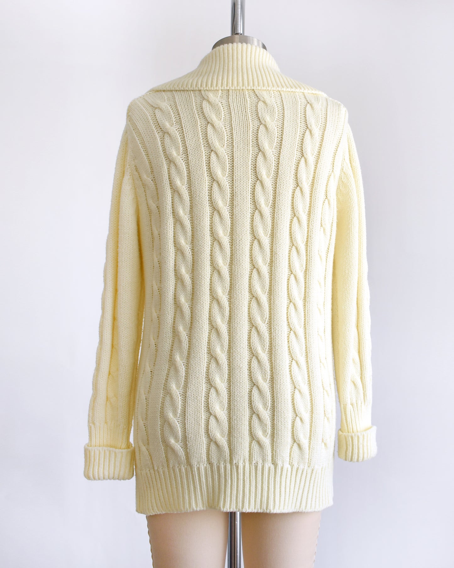 back view of a vintage 1970s cream cable knit cardigan