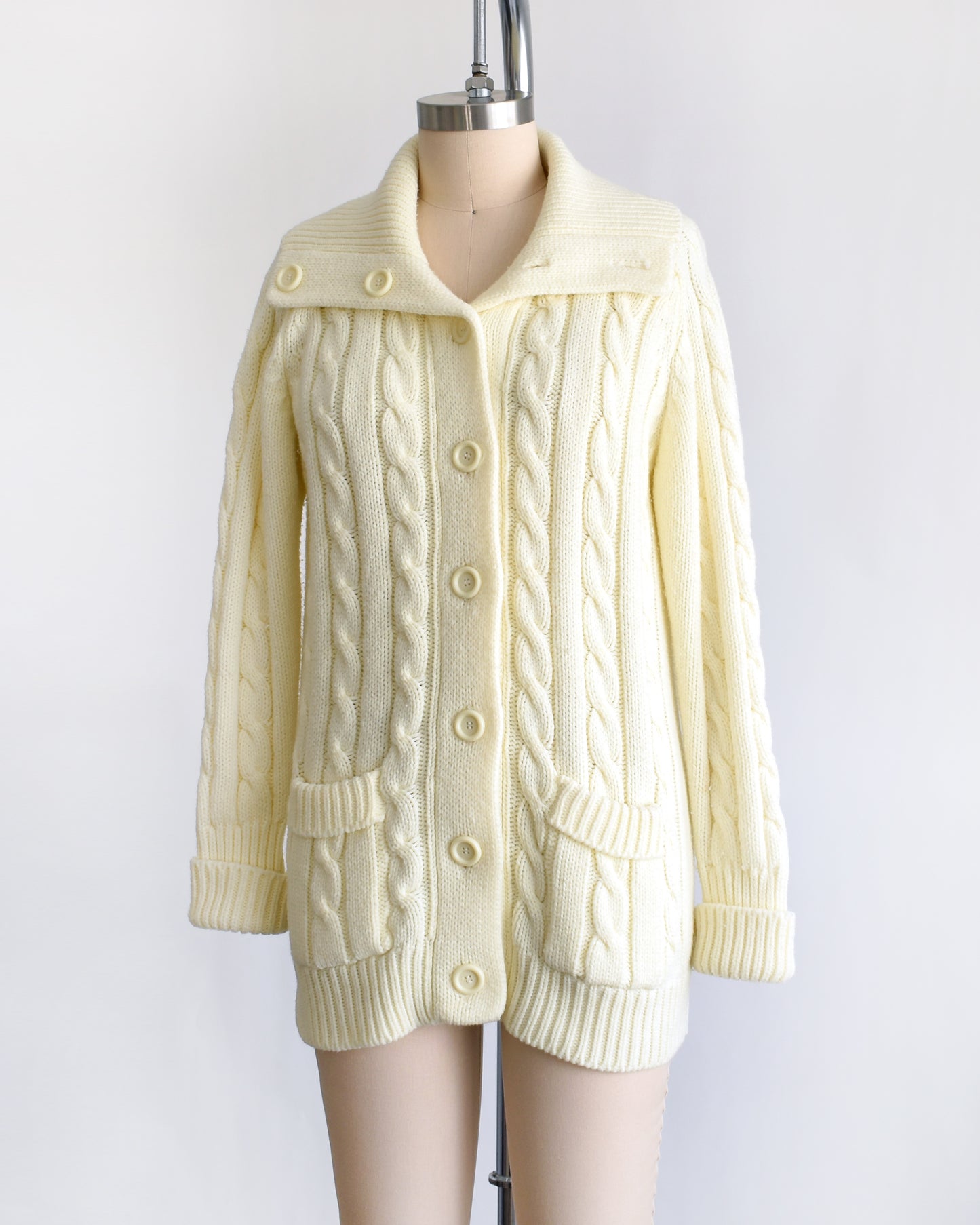 side front view of a vintage 1970s cream cable knit cardigan