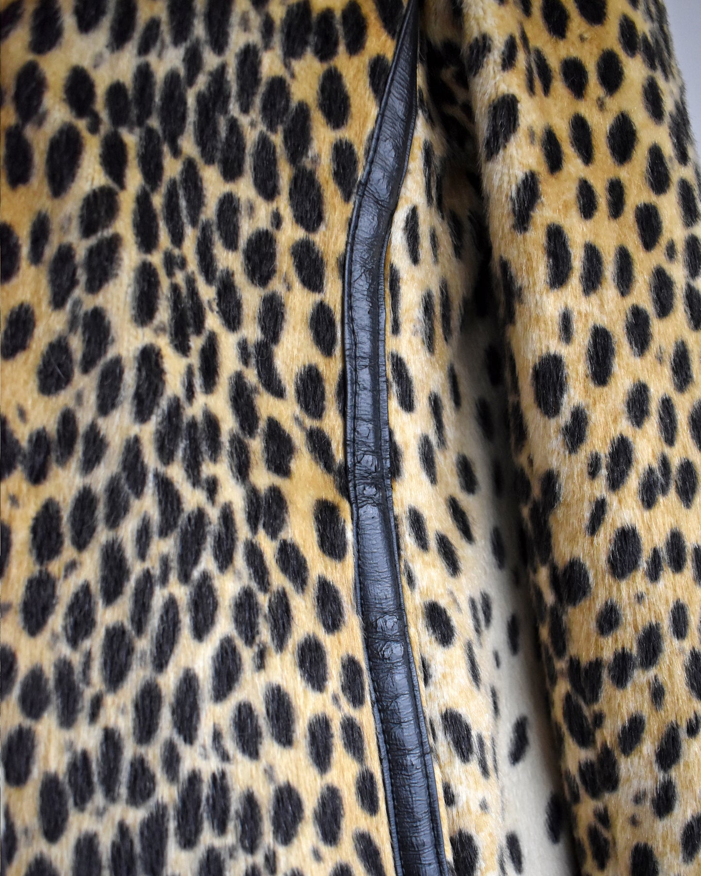 Close up of the black faux leather trim on the side. The leather shows some cracking.