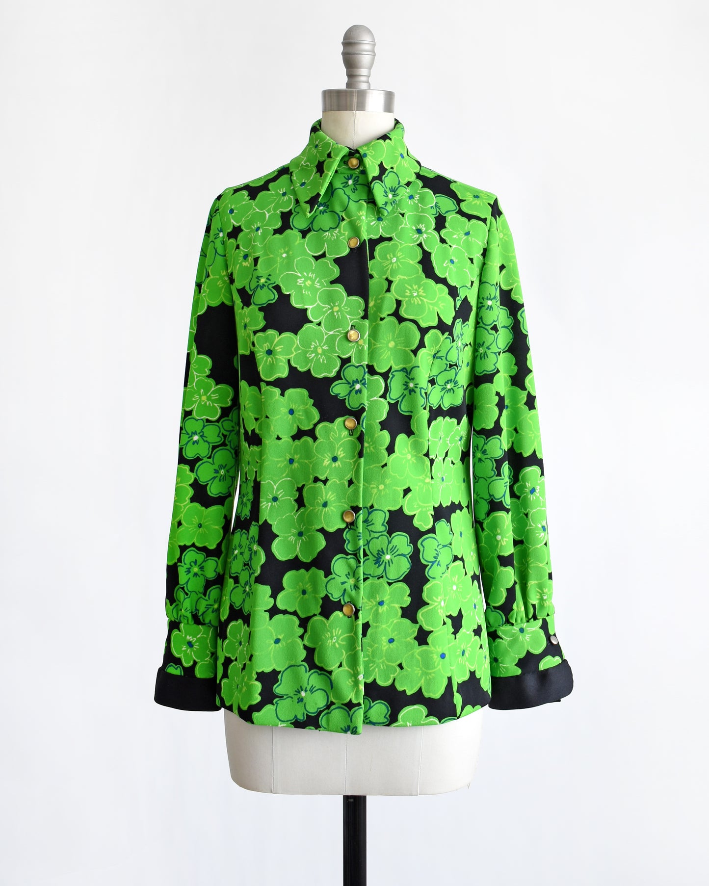 A vintage 1970s green and black floral blouse with yellow buttons down the front