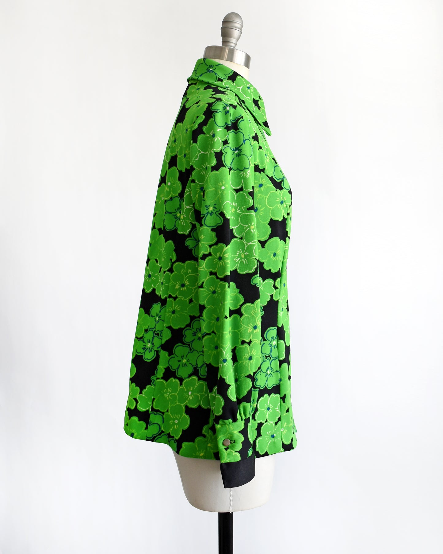 side view of a vintage 1970s green and black floral blouse