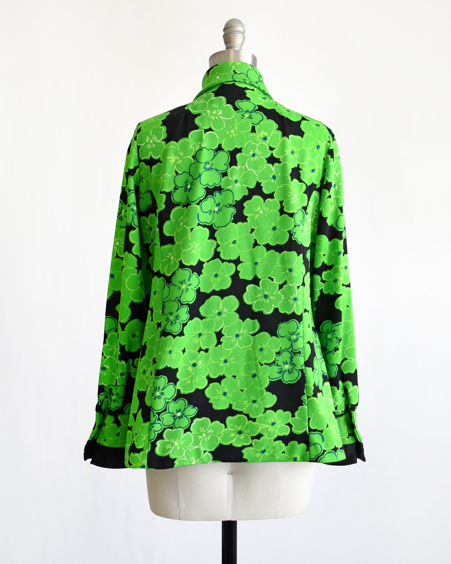 back view of a vintage 1970s green and black floral blouse
