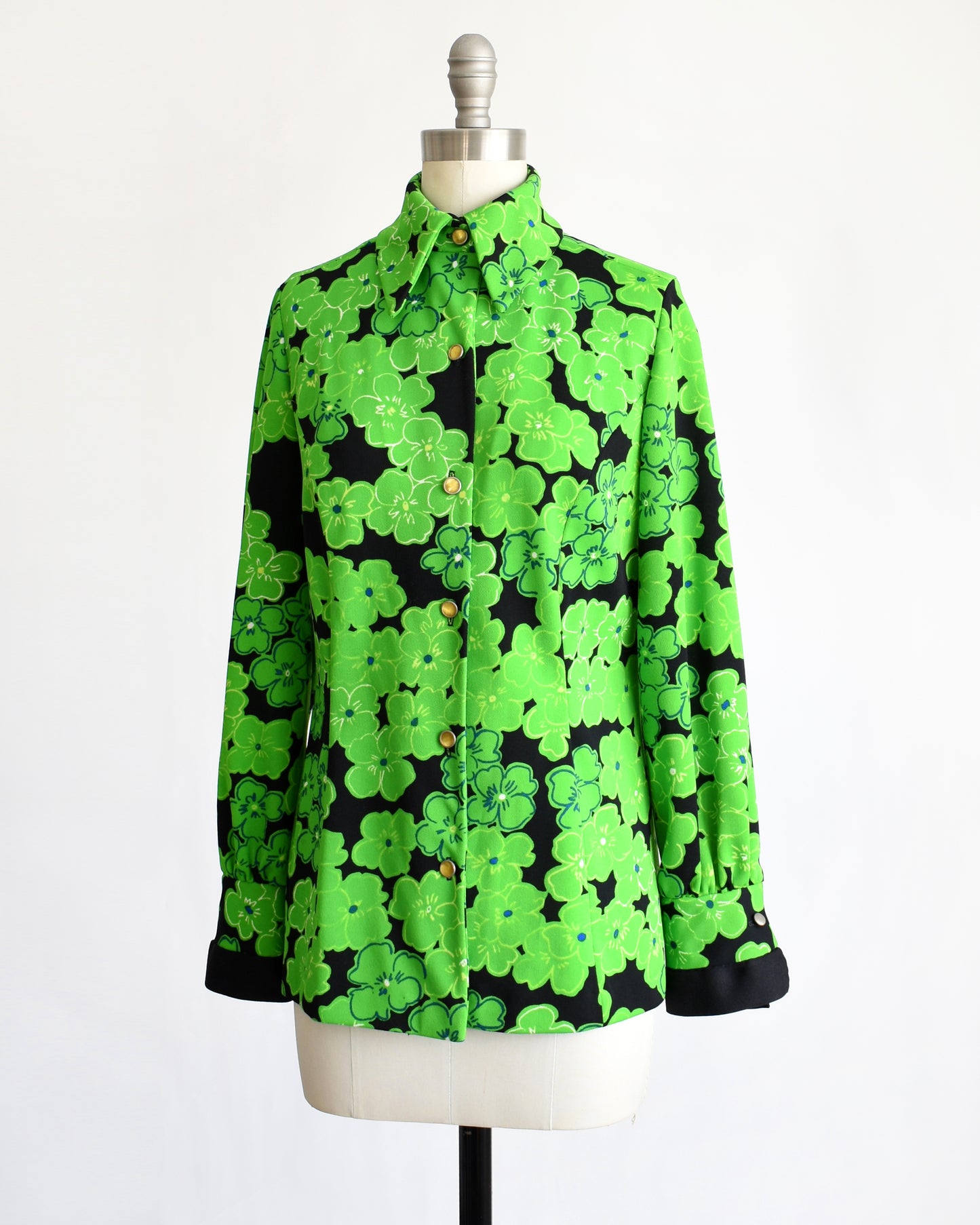 side front view of a vintage 1970s green and black floral blouse
