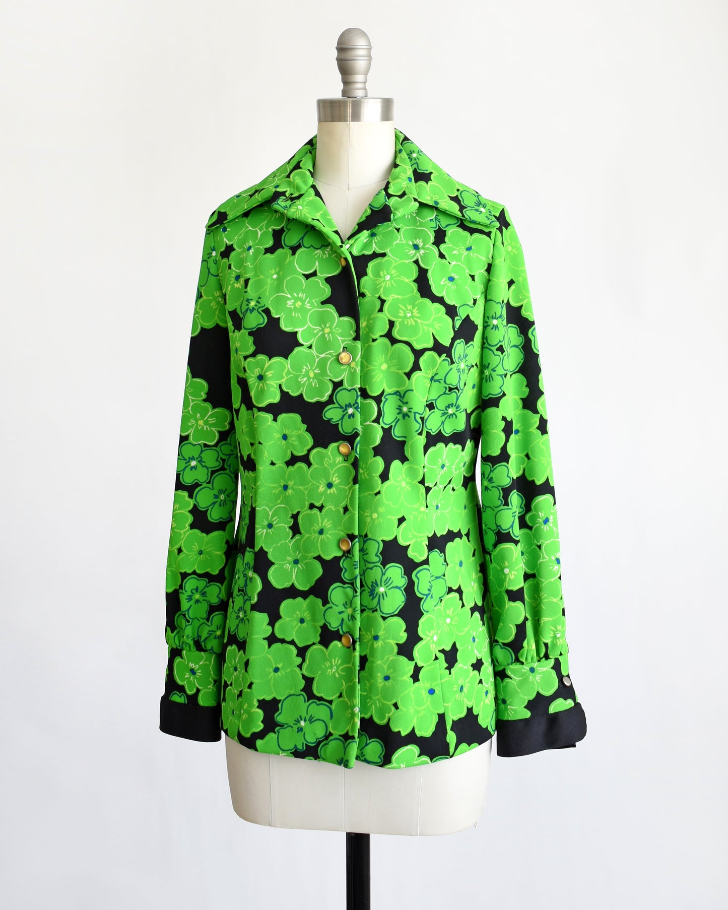 side front view of a vintage 1970s green and black floral blouse