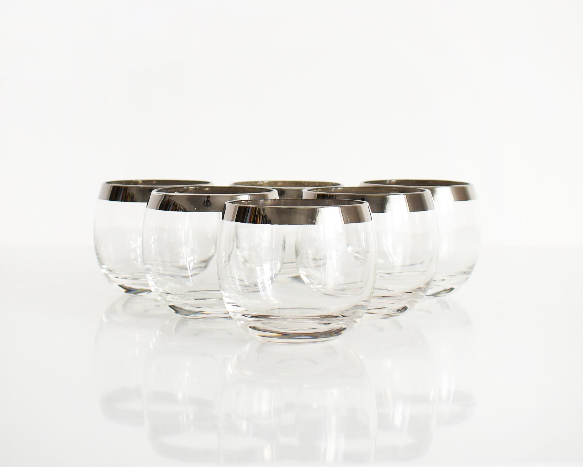 A set of six mid century roly poly glasses with silver rims.