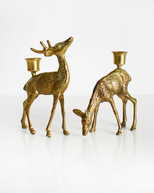 Vintage pair of brass deer figurine candle holders. The buck is standing upright displaying his antlers and the doe is grazing on the ground.