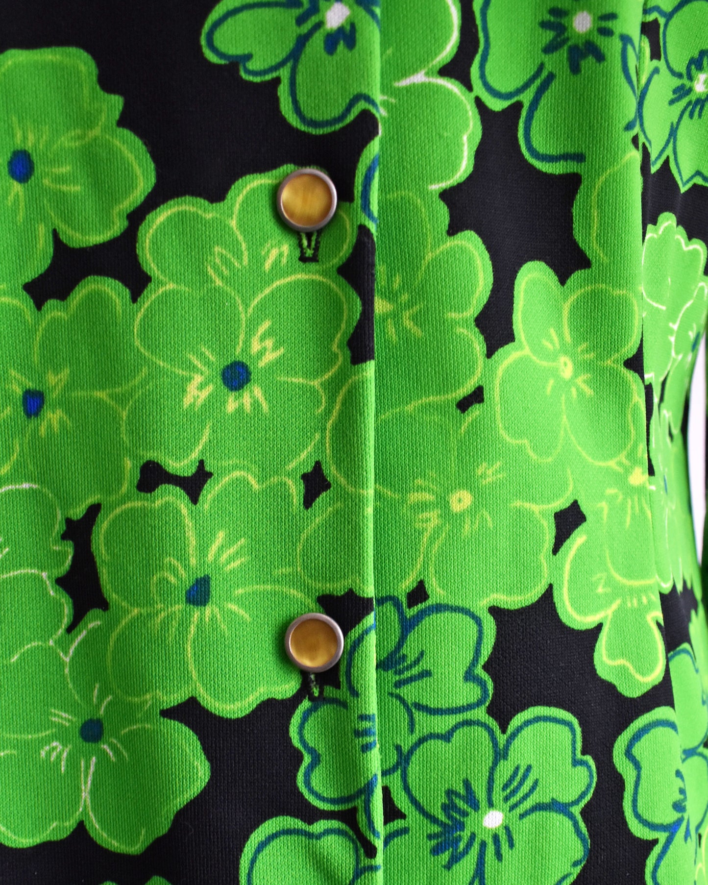 close up of the green floral print and yellow buttons